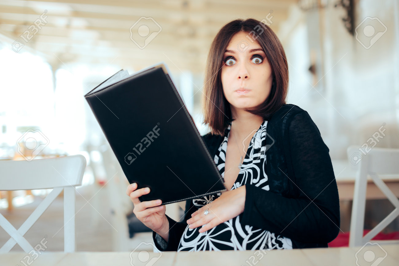 Funny Hungry Pregnant Woman Holding a Food Menu - 171415170 Funny Hungry Pregnant Woman Holding a Food Menu - 171415170