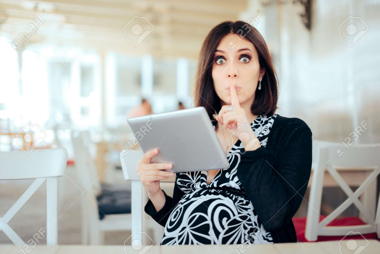 Secretive Pregnant Woman Holding Pc Tablet - 171424910 Secretive Pregnant Woman Holding Pc Tablet - 171424910
