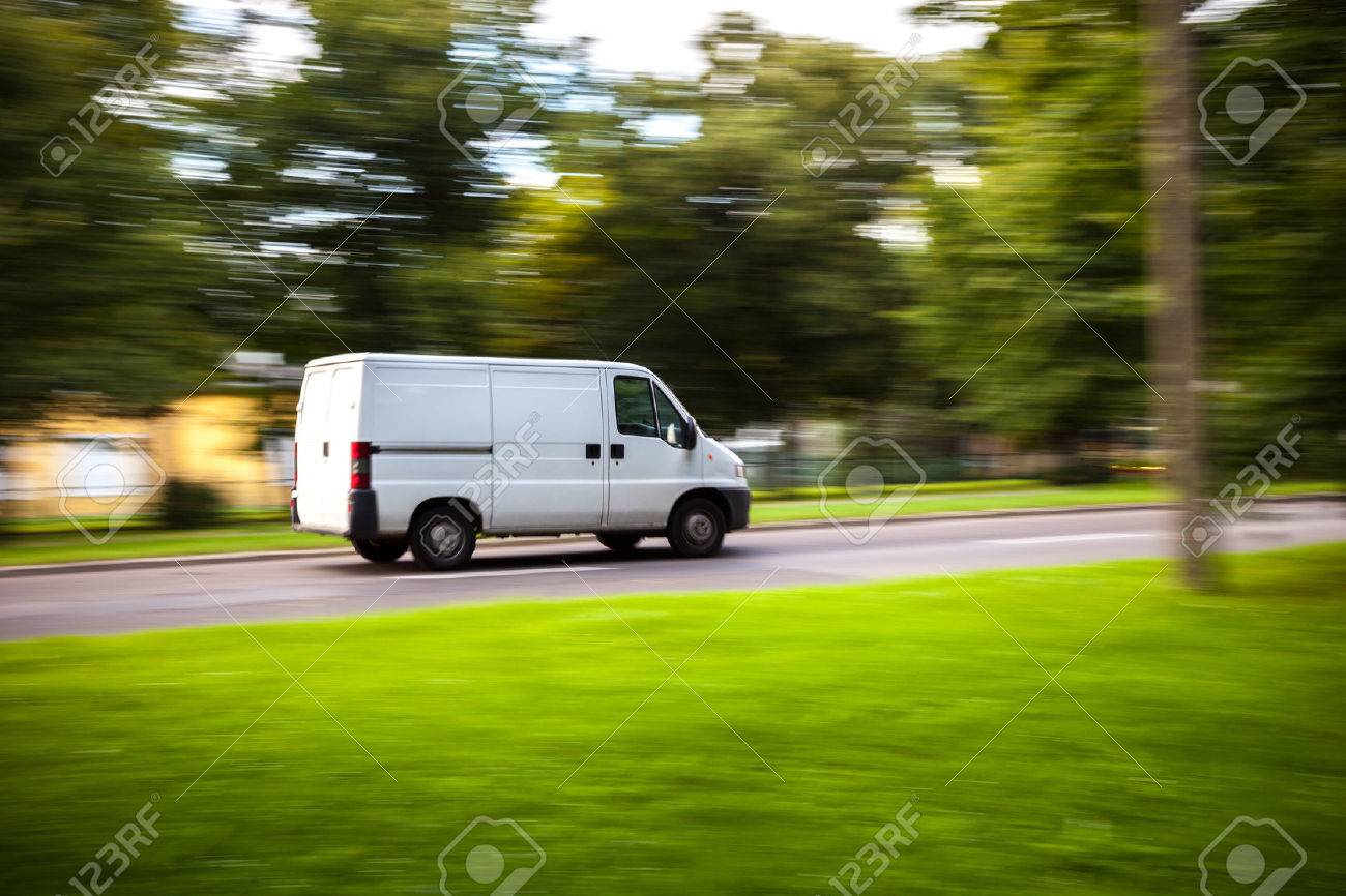 White delivery van speeding on road with blurred countryside panorama in background. - 37513596 White delivery van speeding on road with blurred countryside panorama in background. - 37513596