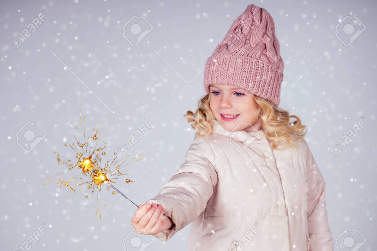 charming little girl in a knitted hat holding fireworks on white background in a studio.Cute blonde child with xmas dream.Happy kid enjoy the fire sparks. new year holidays eve of Christmas a wish - 132637624 charming little girl in a knitted hat holding fireworks on white background in a studio.Cute blonde child with xmas dream.Happy kid enjoy the fire sparks. new year holidays eve of Christmas a wish - 132637624