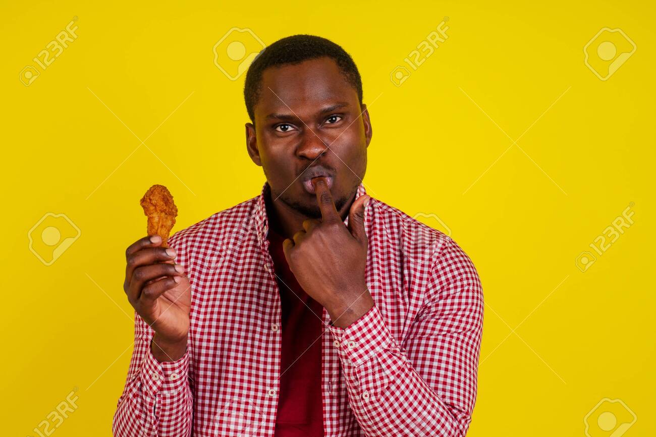 Funny African American Man Eating Fried Chicken Leg In Studio Yellow  Background Stock Photo, Picture and Royalty Free Image. Image 132746826., image size:1300x866