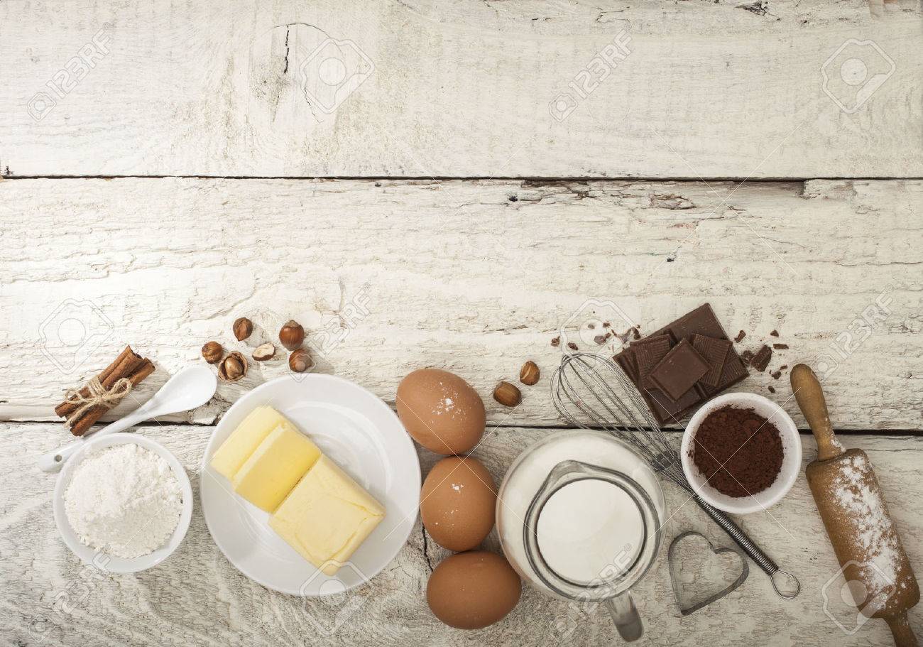 Ingredients for the preparation of bakery products: flour eggs butter milk chocolate cocoa nuts. Top view. Rustic style. White wooden background. - 51085614 Ingredients for the preparation of bakery products: flour eggs butter milk chocolate cocoa nuts. Top view. Rustic style. White wooden background. - 51085614