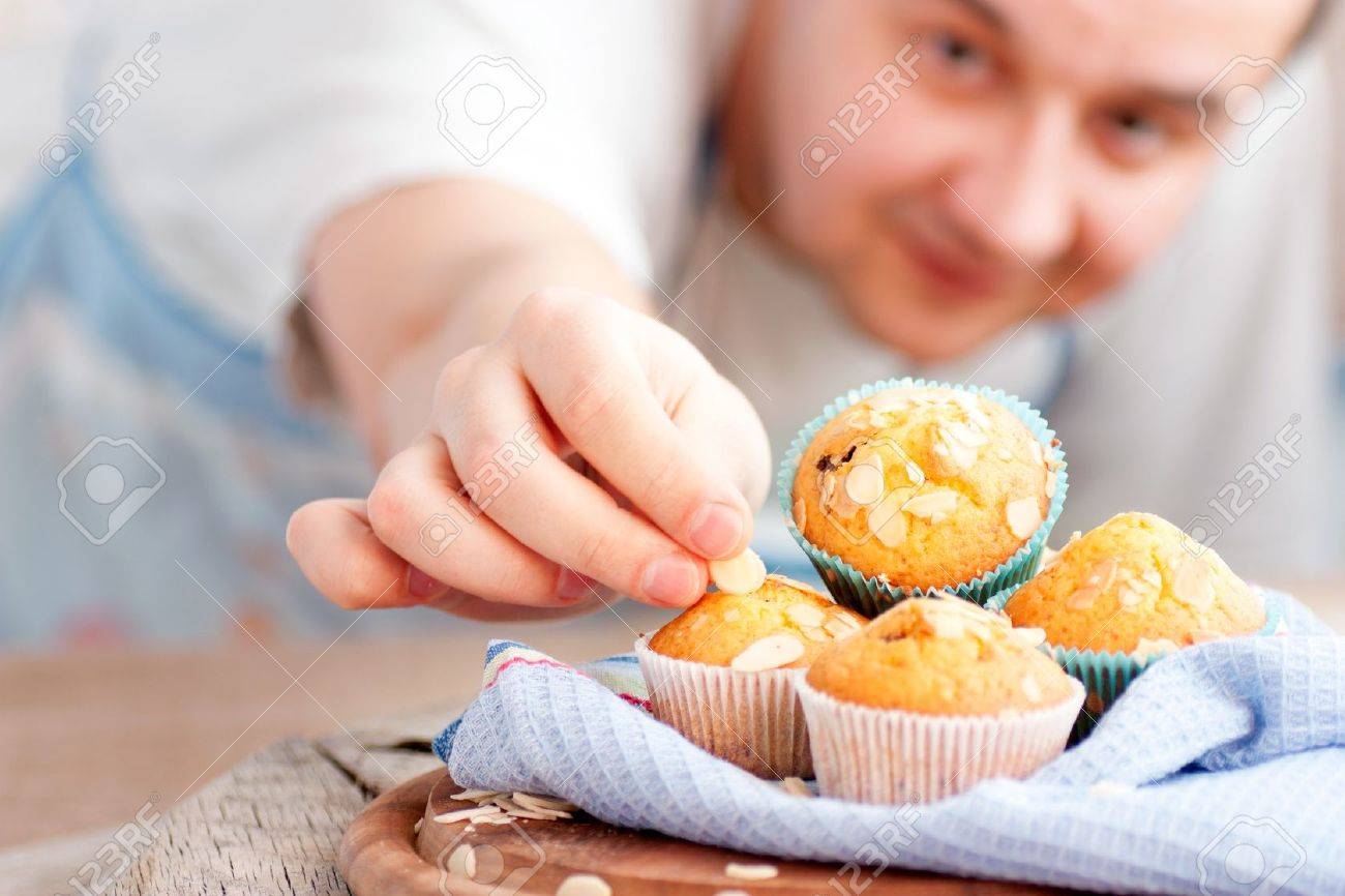 Chef is decorating delicious organic muffins Almond and cherry cup cakes in natural setting - 12812664 Chef is decorating delicious organic muffins Almond and cherry cup cakes in natural setting - 12812664