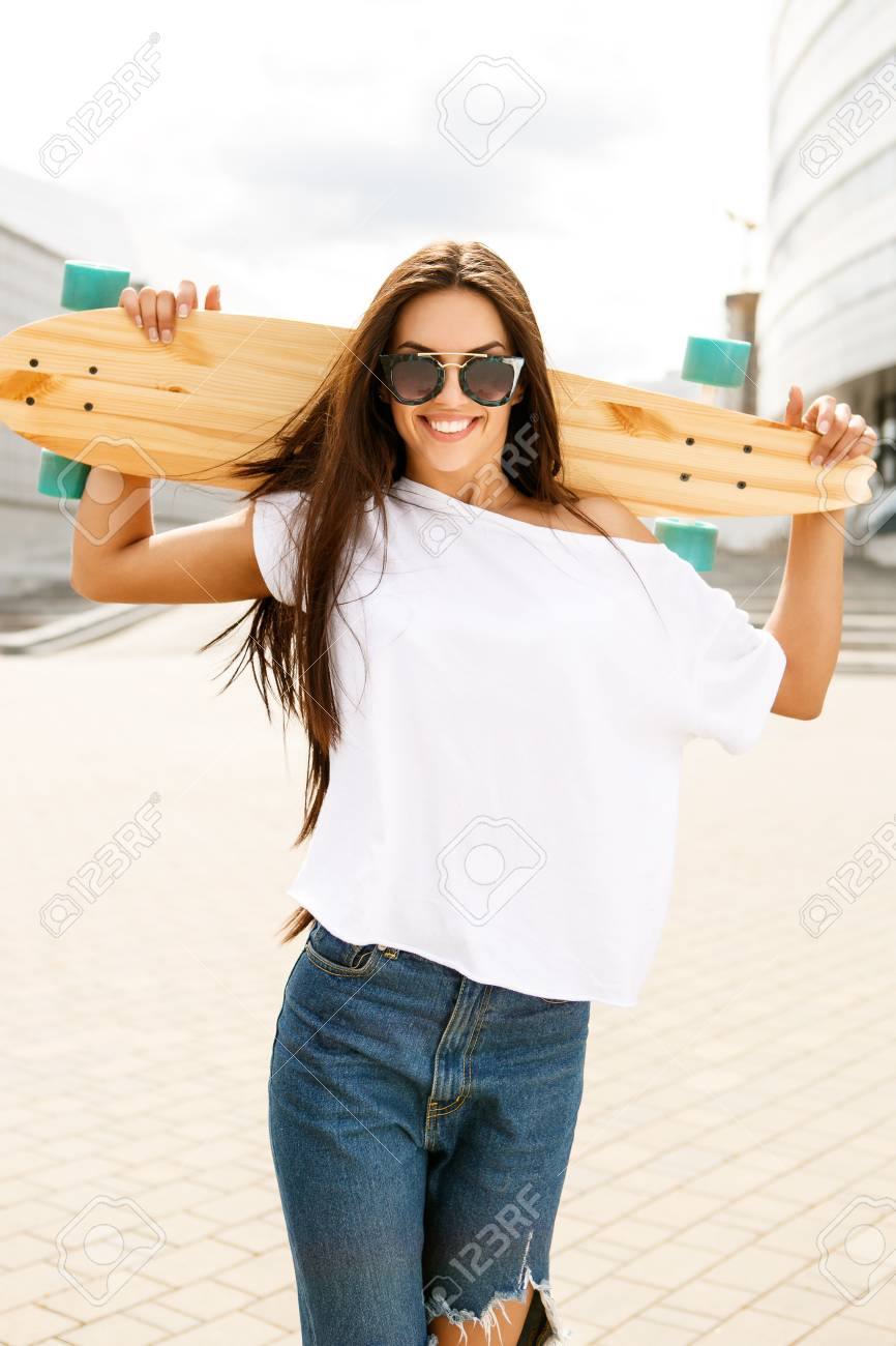 ファッション サングラス カジュアルな白の T シャツと破れたジーンズの女性は幸せなビジネスの前に彼女の木製ロング スケート ボードと一緒にまたはスポーツの建物 かわいい女性は 楽しい時を過すし カメラに笑顔します の写真素材 画像素材 Image ファッション サングラス カジュアルな白の T シャツと破れたジーンズの女性は幸せなビジネスの前に彼女の木製ロング スケート ボードと一緒にまたはスポーツの建物 かわいい女性は 楽しい時を過すし カメラに笑顔します の写真素材 画像素材 Image
