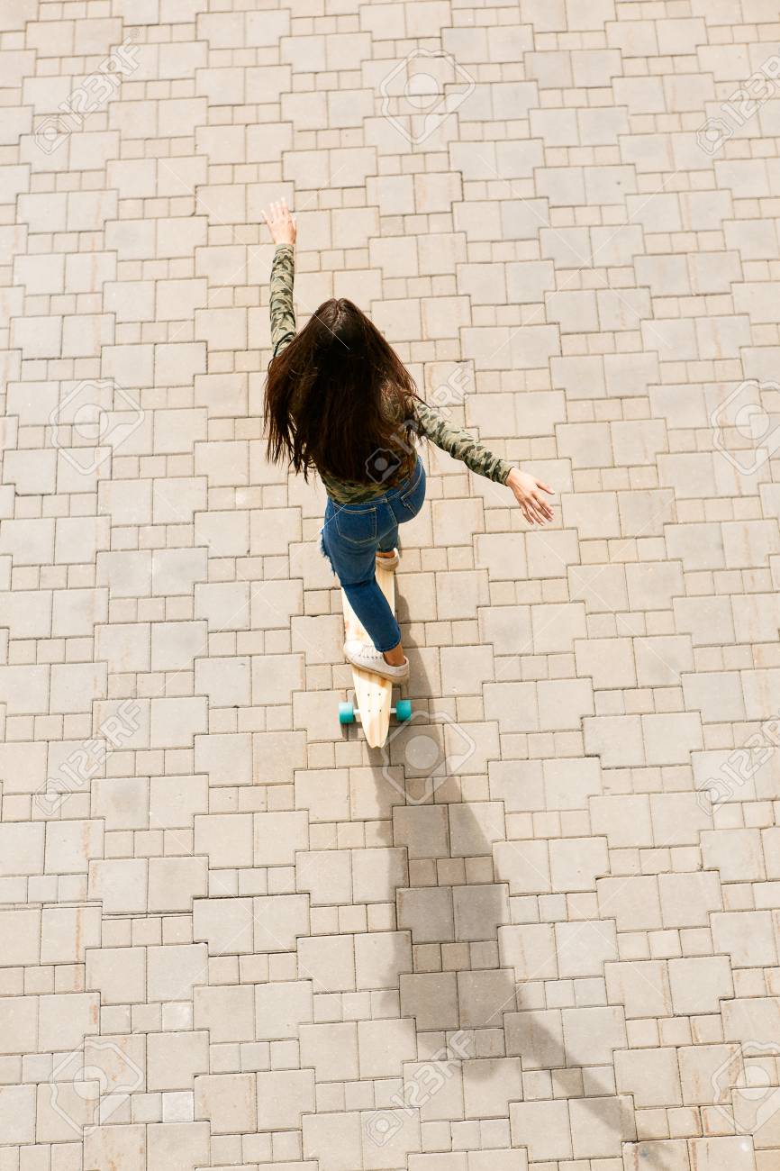 ファッション サングラスで髪の長い健康的な幸せな美しい女の子 カジュアルな服は木製ロング スケート ボードに乗る かわいい流行に敏感な女性に乗っています 都市風景 都市生活 上から平面図です の写真素材 画像素材 Image