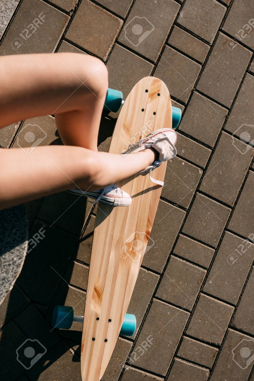 休憩後 極端な面白い彼女の木製ロング スケート ボードに乗る白いスニーカーでスリムな女性足のクローズ アップ モダンな都市内気な少女は 楽しい時を過します スケート ボードの良い日当たりの良い夏の日と 楽しい時を過します の写真素材 画像素材 Image