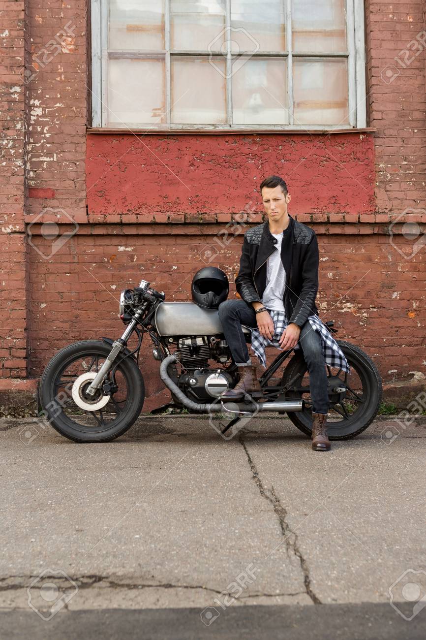 黒い革のジャケット ジーンズ ブーツでハンサムなライダー バイクに乗る男はクラシックなスタイルのカフェ レーサー バイクの上に座る バイク カスタム ヴィンテージ ガレージで行われました 残忍な都会のライフ スタイルを楽しい 屋外のポートレート の写真素材 黒い革のジャケット ジーンズ ブーツでハンサムなライダー バイクに乗る男はクラシックなスタイルのカフェ レーサー バイクの上に座る バイク カスタム ヴィンテージ ガレージで行われました 残忍な都会のライフ スタイルを楽しい 屋外のポートレート の写真素材