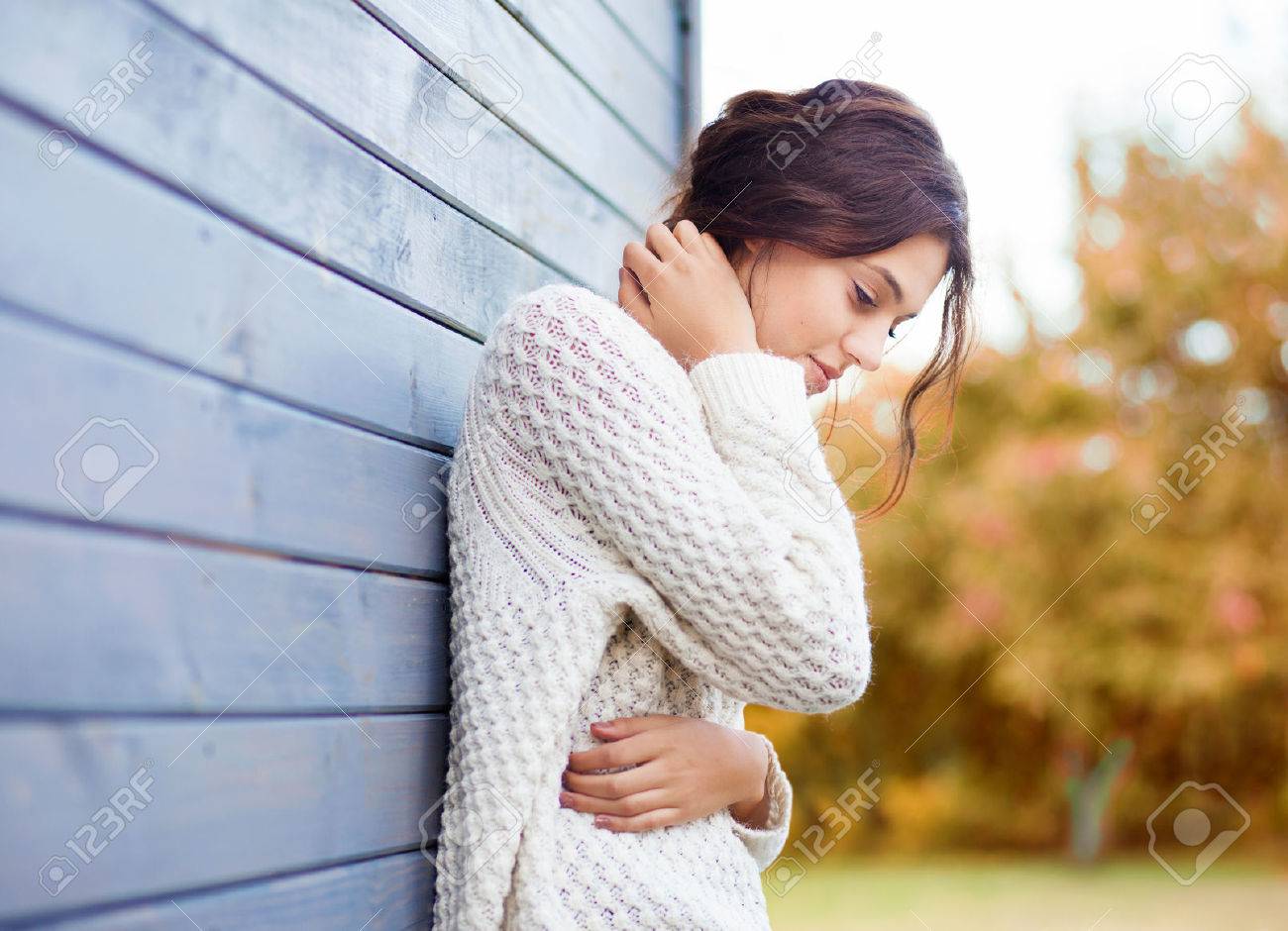 Beautiful natural young brunette woman wearing knitted sweater by the house. Fall and winter fashion concept. - 45215478 Beautiful natural young brunette woman wearing knitted sweater by the house. Fall and winter fashion concept. - 45215478