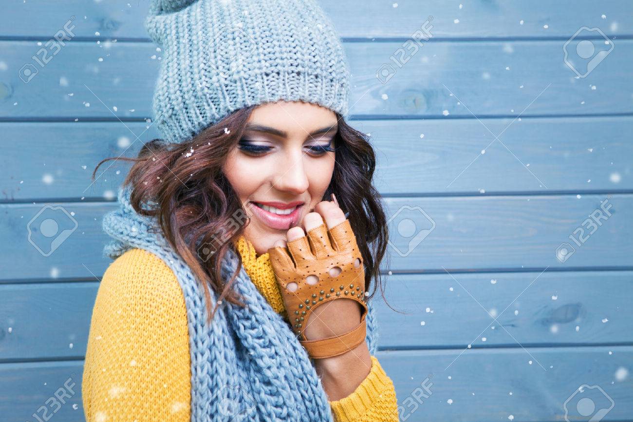 Beautiful natural young smiling brunette woman wearing knitted sweater, leather gloves, scarf and hat. Covered with snow flakes. Fall and winter fashion concept. - 48120114 Beautiful natural young smiling brunette woman wearing knitted sweater, leather gloves, scarf and hat. Covered with snow flakes. Fall and winter fashion concept. - 48120114