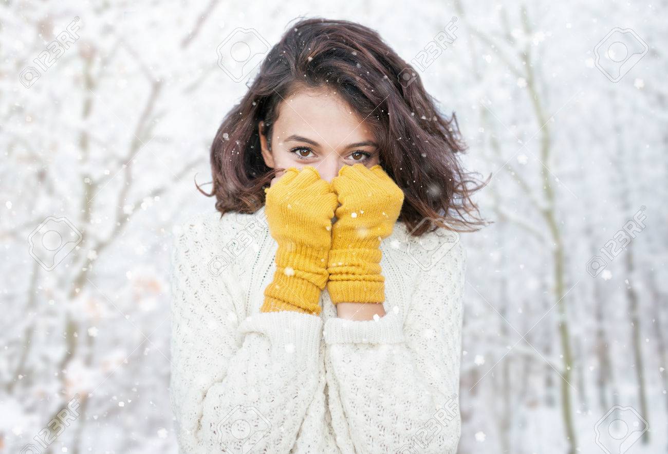 Beautiful natural young smiling brunette woman wearing knitted sweater and glove in the woods. Snowing snow winter concept. - 75042786 Beautiful natural young smiling brunette woman wearing knitted sweater and glove in the woods. Snowing snow winter concept. - 75042786