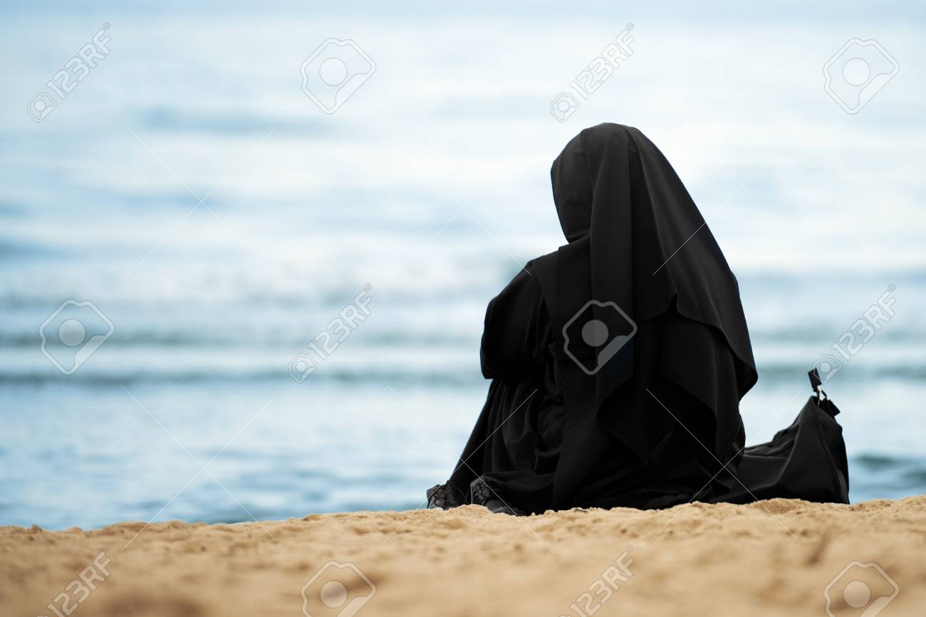 86577970-muslim-woman-with-black-clothes-sitting-on-the-beach.jpg