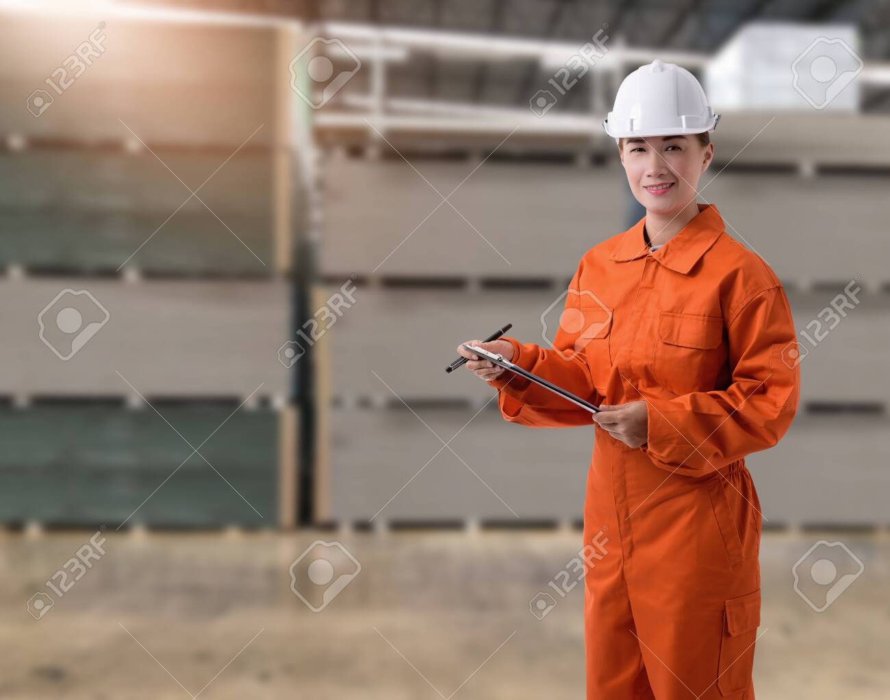 Portrait of Female staff warehouse operator with Blurred the background of Construction material on product shelf in store - 148082217 Portrait of Female staff warehouse operator with Blurred the background of Construction material on product shelf in store - 148082217