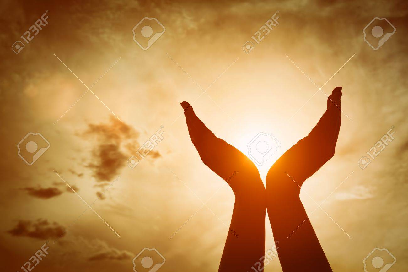 Raised hands catching sun on sunset sky. Concept of spirituality, wellbeing, positive energy etc. - 61712972 Raised hands catching sun on sunset sky. Concept of spirituality, wellbeing, positive energy etc. - 61712972