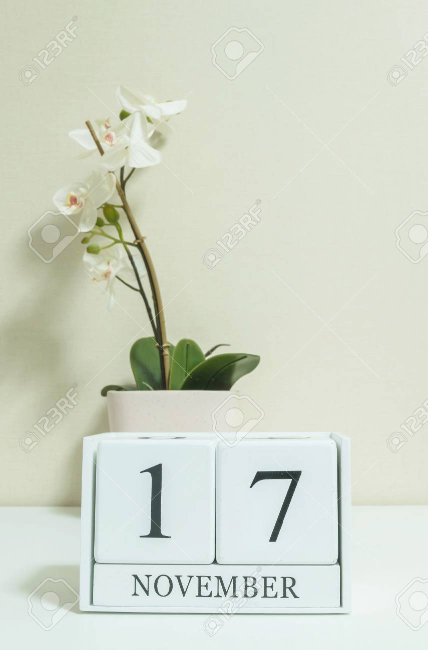 白い木製の机と部屋でクリーム色の壁紙に白い蘭の花と黒 11 月 17 日の言葉でクローズ アップ ホワイト木製カレンダー テクスチャ背景 カレンダーで選択と集中 の写真素材 画像素材 Image