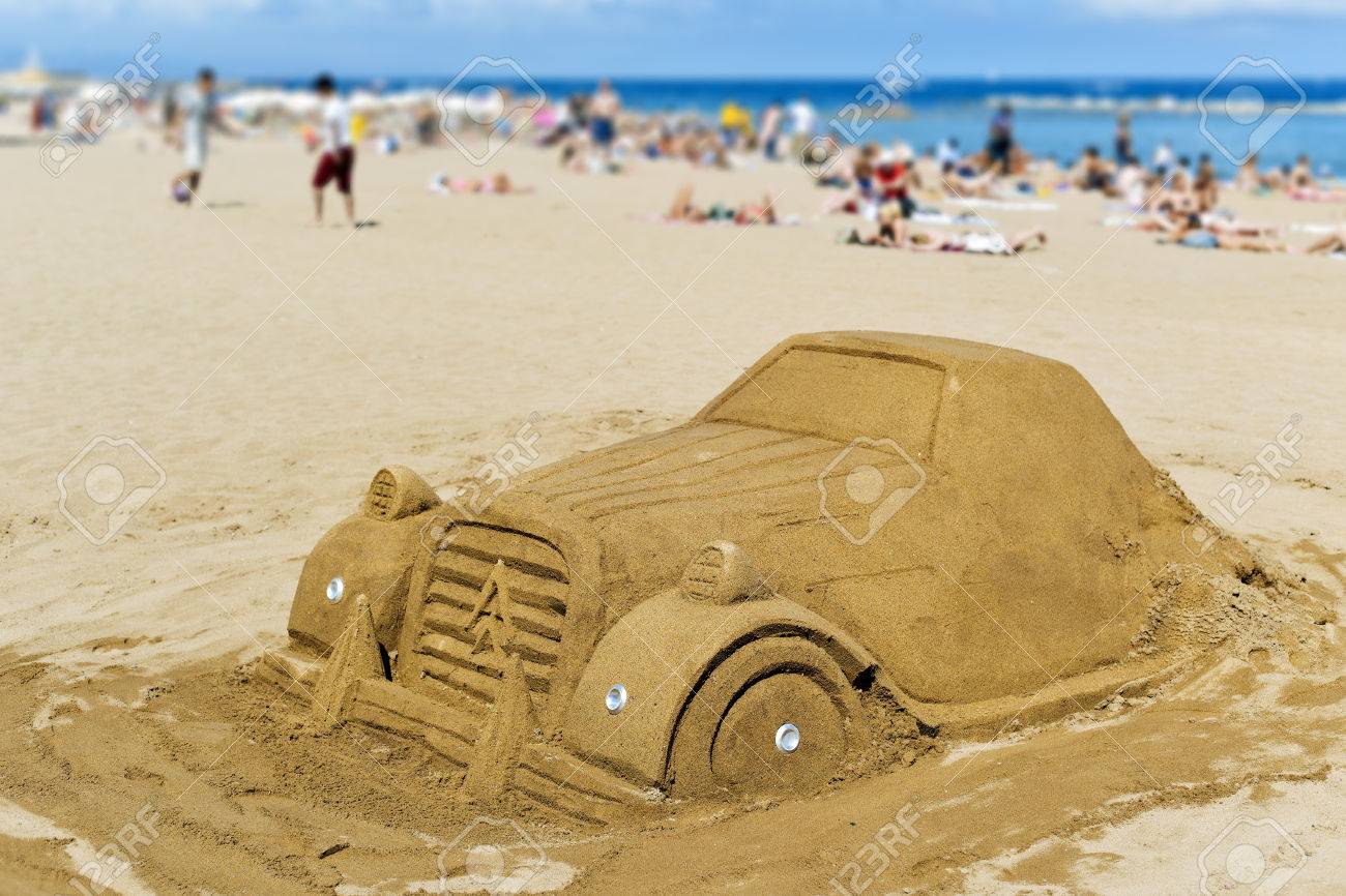 Une Sculpture De Sable Dans La Forme Dune Voiture à La Plage De Barceloneta à Barcelone En Espagne Avec Des Gens Méconnaissables Bronzer En