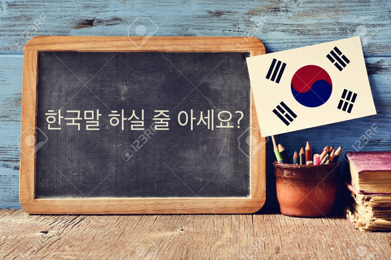 a chalkboard with the question do you speak Korean? written in Korean, a pot with pencils, some books and the flag of South Korea, on a wooden desk - 69205890 a chalkboard with the question do you speak Korean? written in Korean, a pot with pencils, some books and the flag of South Korea, on a wooden desk - 69205890