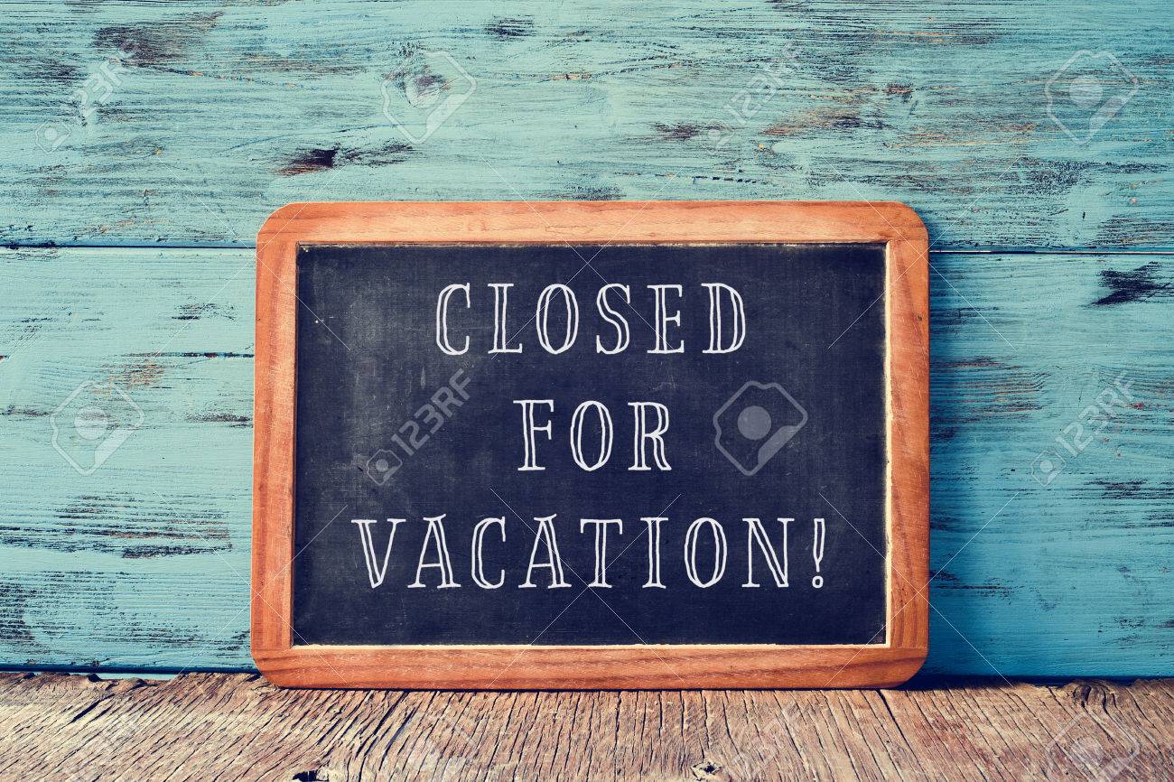 a wooden-framed chalkboard with the text closed for vacation written in it, on a rustic wooden surface, against a blue wooden background - 63160011 a wooden-framed chalkboard with the text closed for vacation written in it, on a rustic wooden surface, against a blue wooden background - 63160011