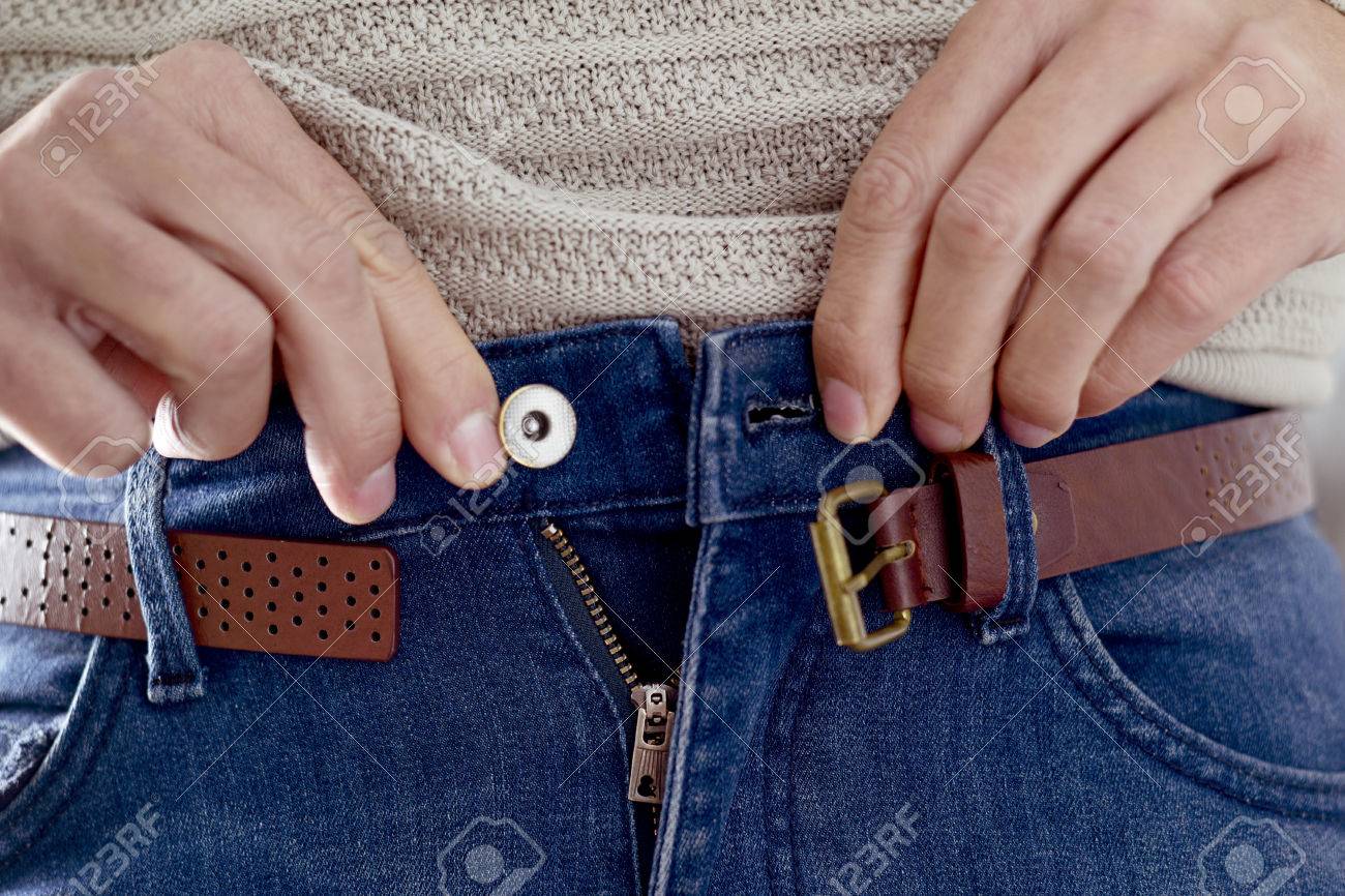 closeup of a young caucasian man trying to fasten his trousers, after his weight gain - 68909380 closeup of a young caucasian man trying to fasten his trousers, after his weight gain - 68909380