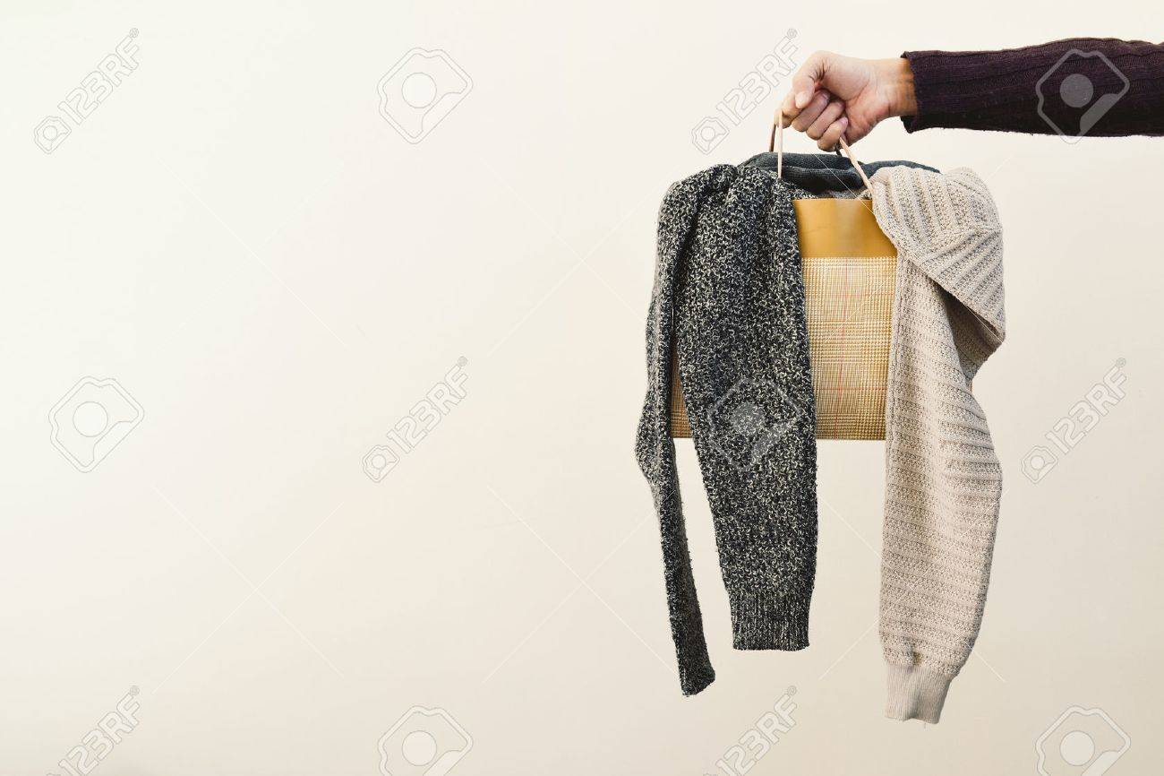 closeup of the hand of a young caucasian man holding a paper shopping bag full of clothes and a negative space to the left - 69227808 closeup of the hand of a young caucasian man holding a paper shopping bag full of clothes and a negative space to the left - 69227808