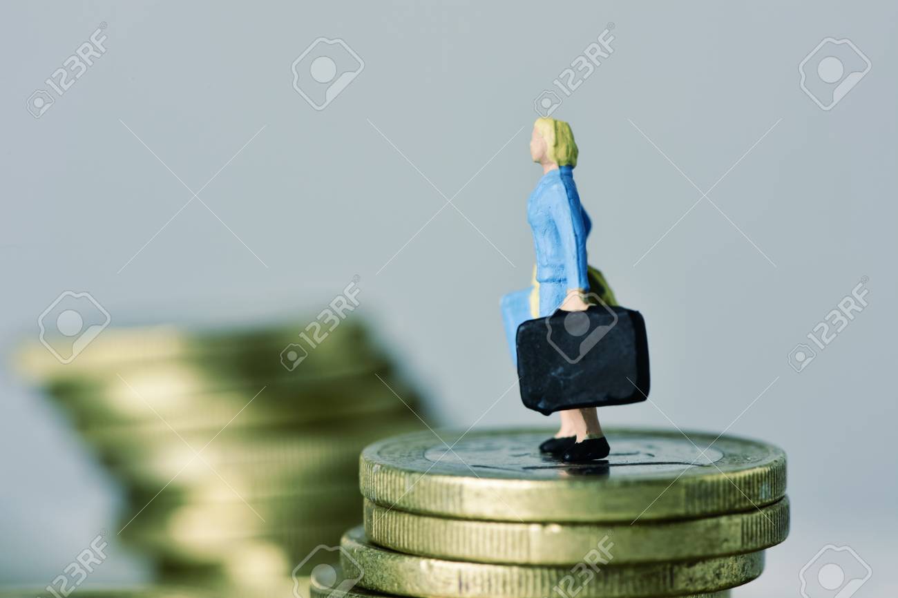 closeup of a miniature woman carrying a suitcase, on the top of a pile of euro coins, with some blank space around her - 93282141 closeup of a miniature woman carrying a suitcase, on the top of a pile of euro coins, with some blank space around her - 93282141
