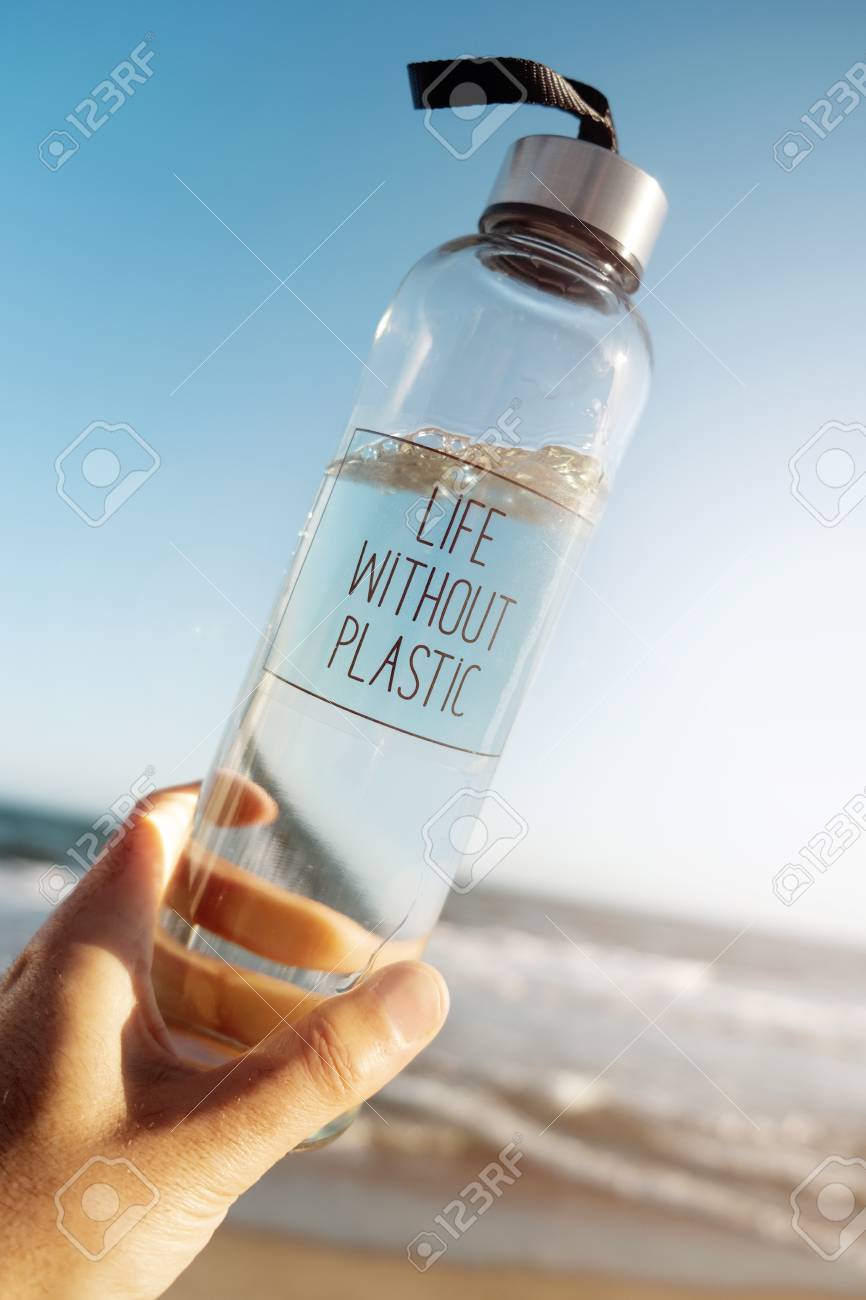 Closeup of a caucasian man holding a glass reusable water bottle with the text life without plastic written - 119130256 Closeup of a caucasian man holding a glass reusable water bottle with the text life without plastic written - 119130256