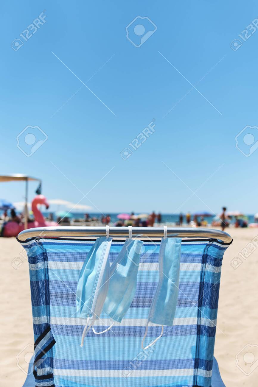 Some Surgical Masks Hanging On A Blue Deck Chair On The Beach With The Sea In The Background Stock Photo Picture And Royalty Free Image Image 152326546