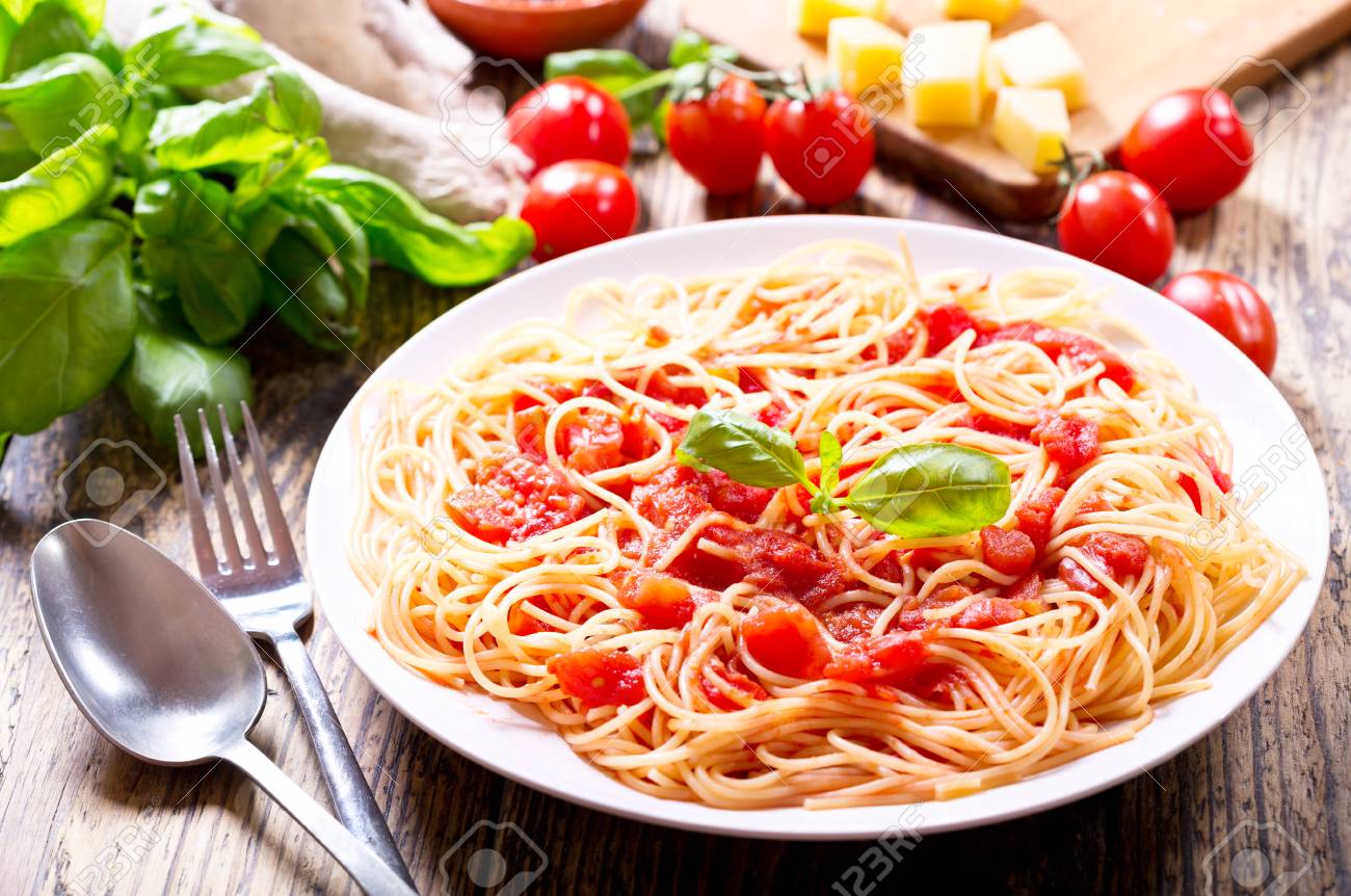 plate of pasta with tomato sauce on wooden table - 55704020 plate of pasta with tomato sauce on wooden table - 55704020