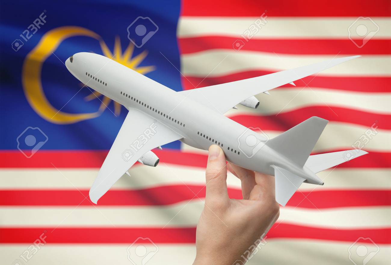 airplane in hand with national flag on background malaysia stock