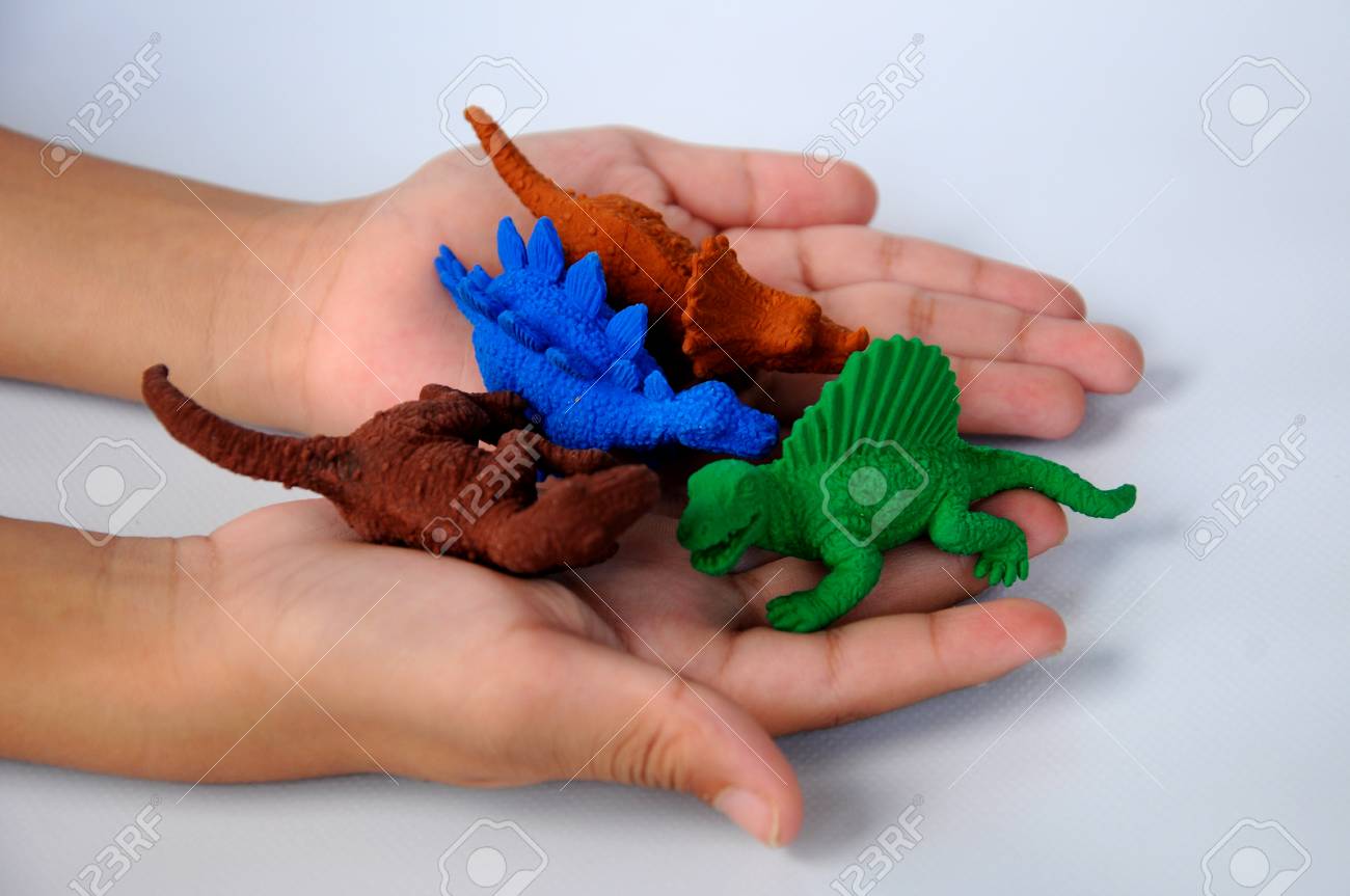 子供は トリケラトプス ステゴサウルス スピノサウルス ティラノサウルスの恐竜モデルを持っている手します モデルは 白い背景で隔離のゴムから行われました の写真素材 画像素材 Image 5323