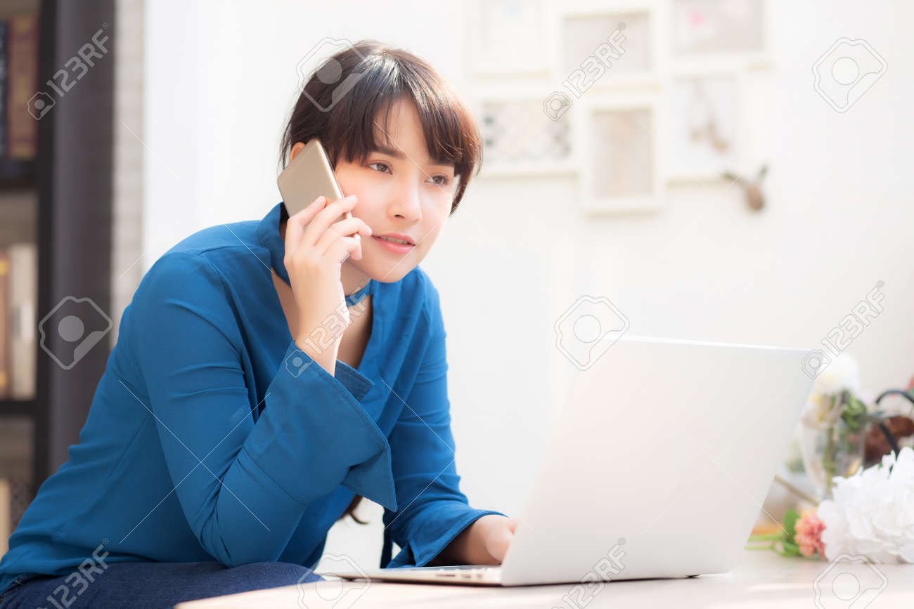 Beautiful asian young businesswoman excited and glad of success work with laptop, girl taking mobile smart phone and working coffee shop, career freelance business concept. - 121450852 Beautiful asian young businesswoman excited and glad of success work with laptop, girl taking mobile smart phone and working coffee shop, career freelance business concept. - 121450852
