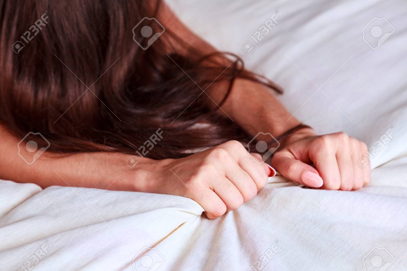 女性のエクスタシー オーガズムの引きの白いシーツを手します の写真素材 画像素材 Image