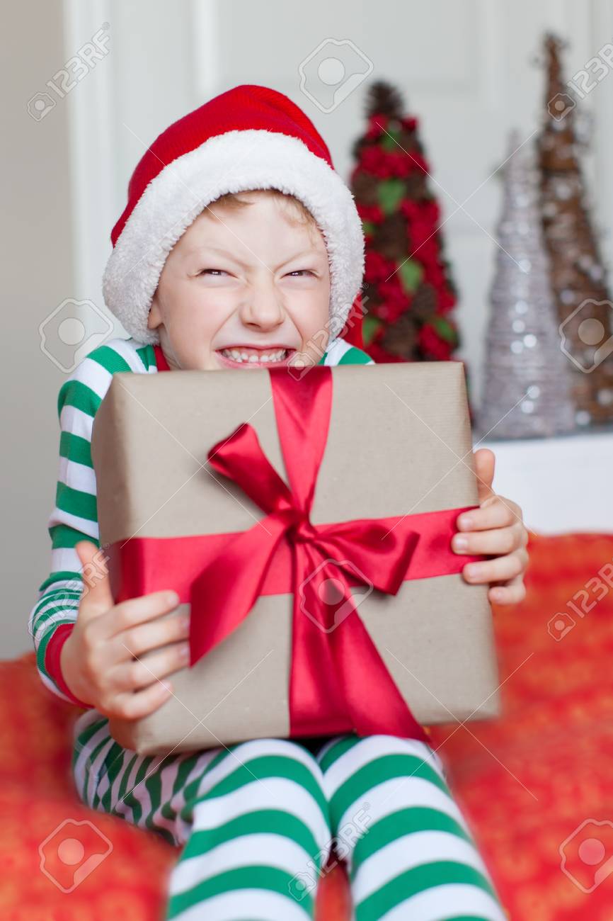 33225725-excited-little-boy-in-santa-hat-at-christmas-time-at-home-holding-nicely-wrapped-present.jpg