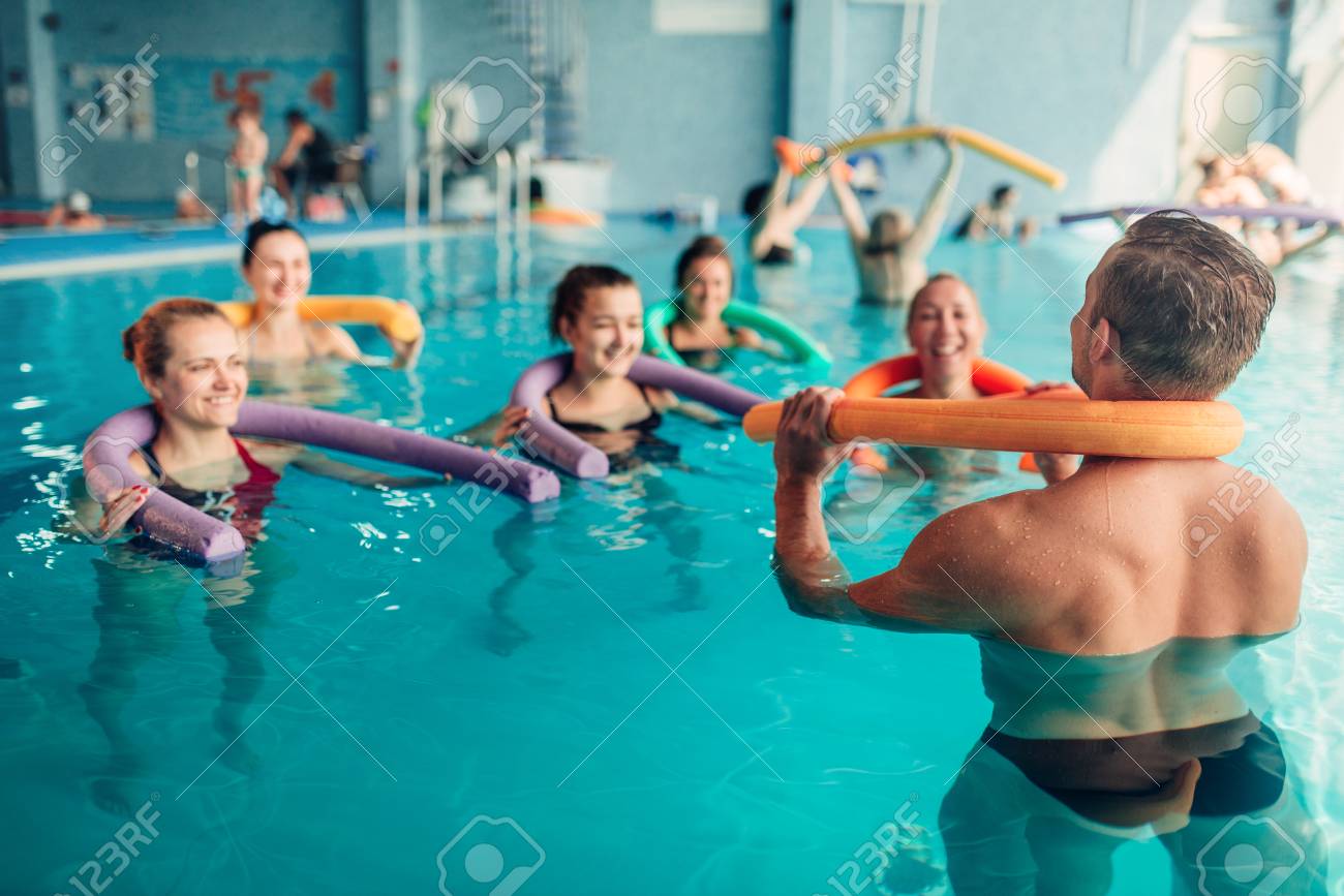 aqua aerobics exercises women with male trainer stock photo