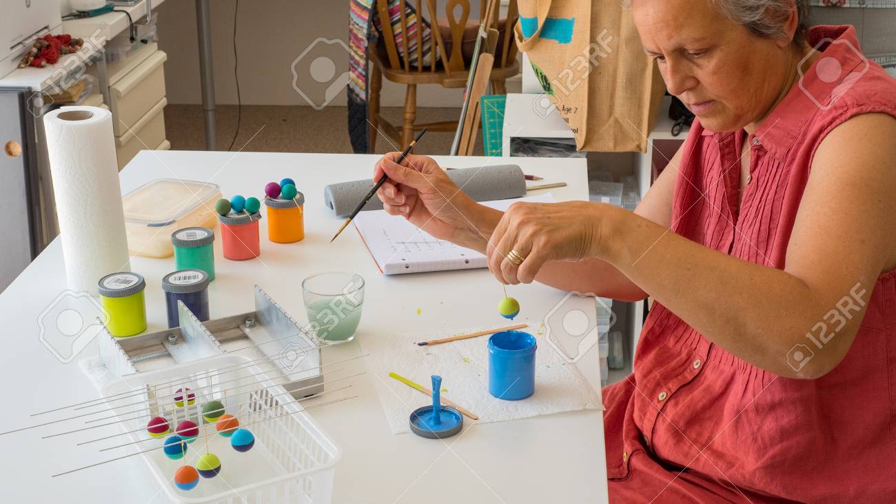 woman painting polymer clay beads. Handmade workshop composition of clay, beads, tools and paint - 80864877 woman painting polymer clay beads. Handmade workshop composition of clay, beads, tools and paint - 80864877