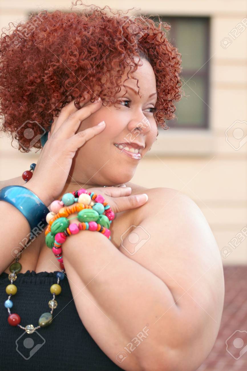 Portrait Of A Female With Short Curly Red Hair And Bright Jewelry