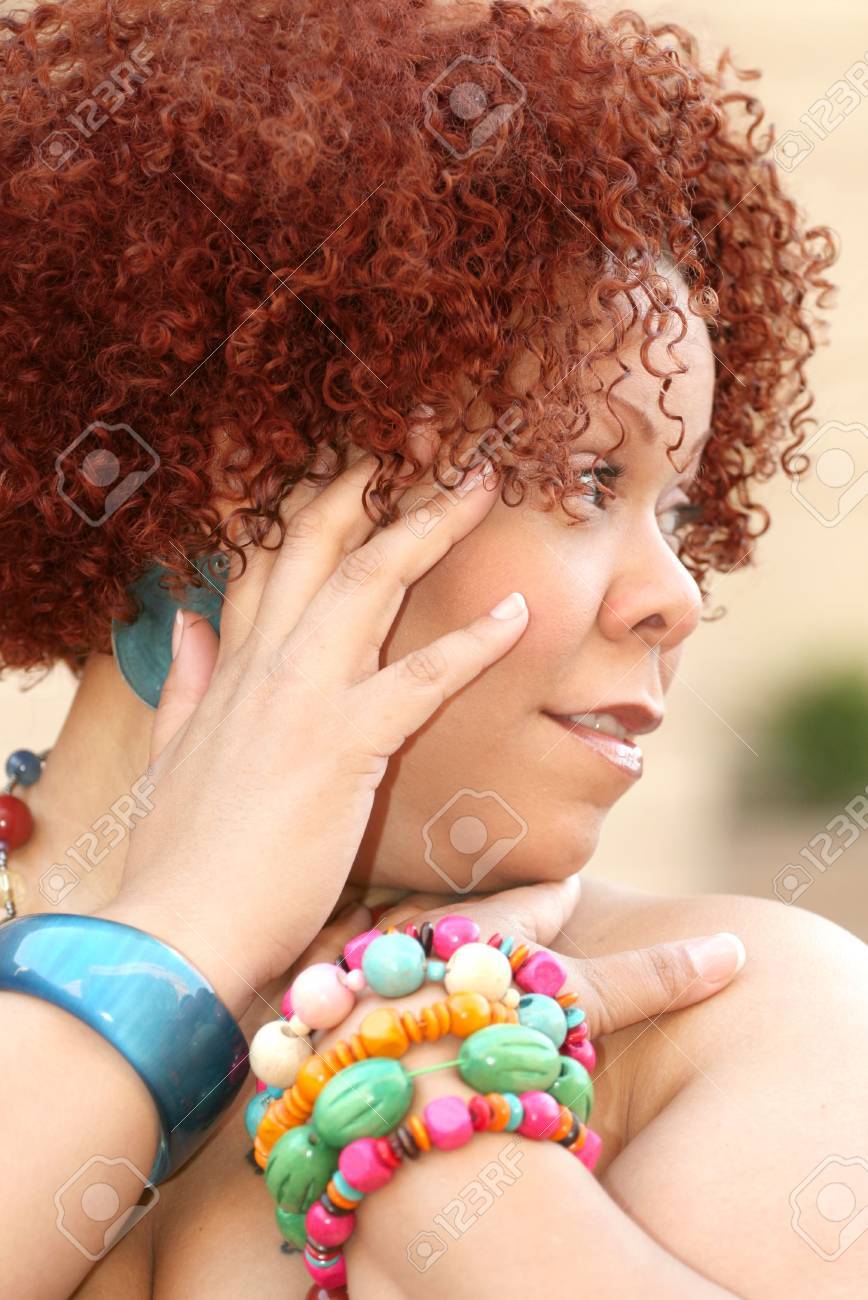 Portrait Of A Female With Short Curly Red Hair And Bright Jewelry