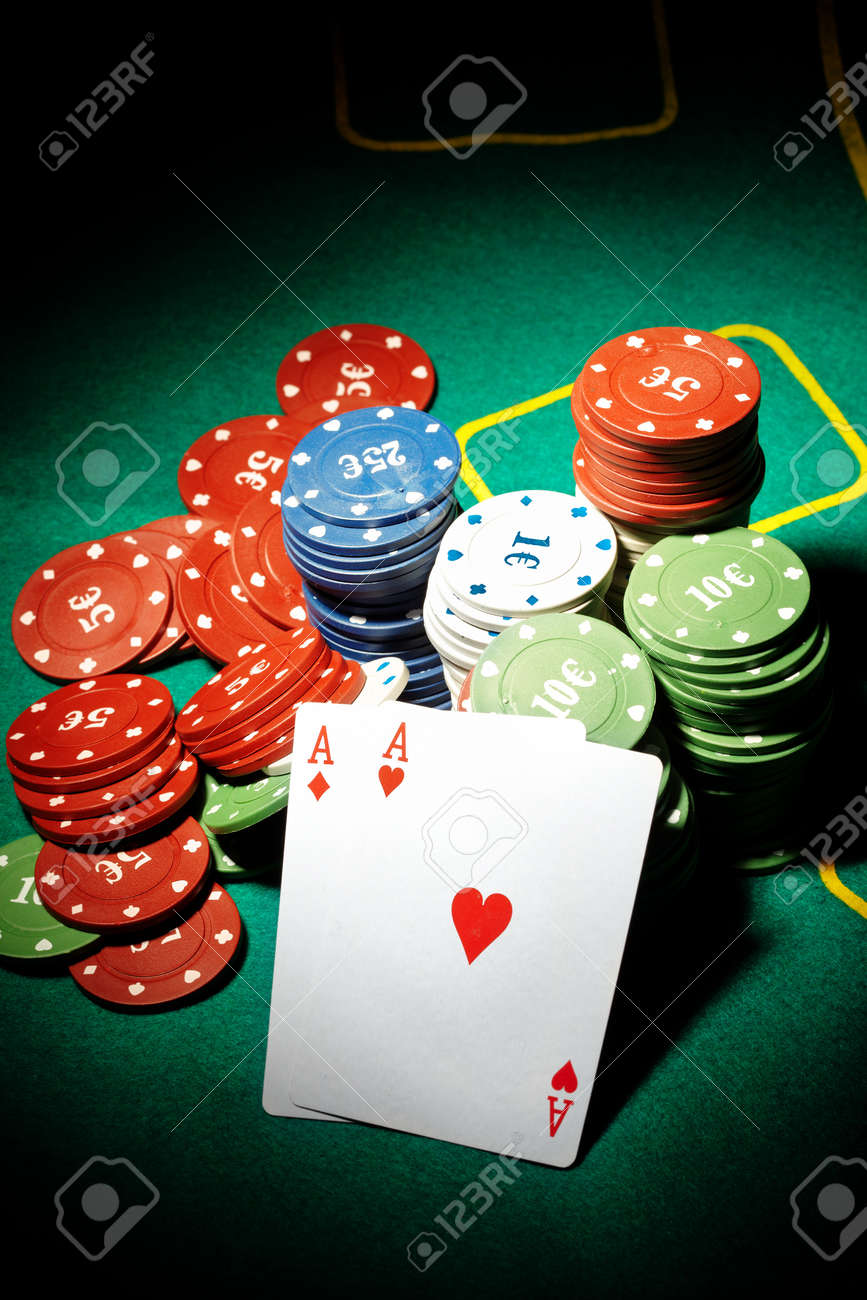 Pair of aces and poker chips on a green table in casino - 8812079 Pair of aces and poker chips on a green table in casino - 8812079