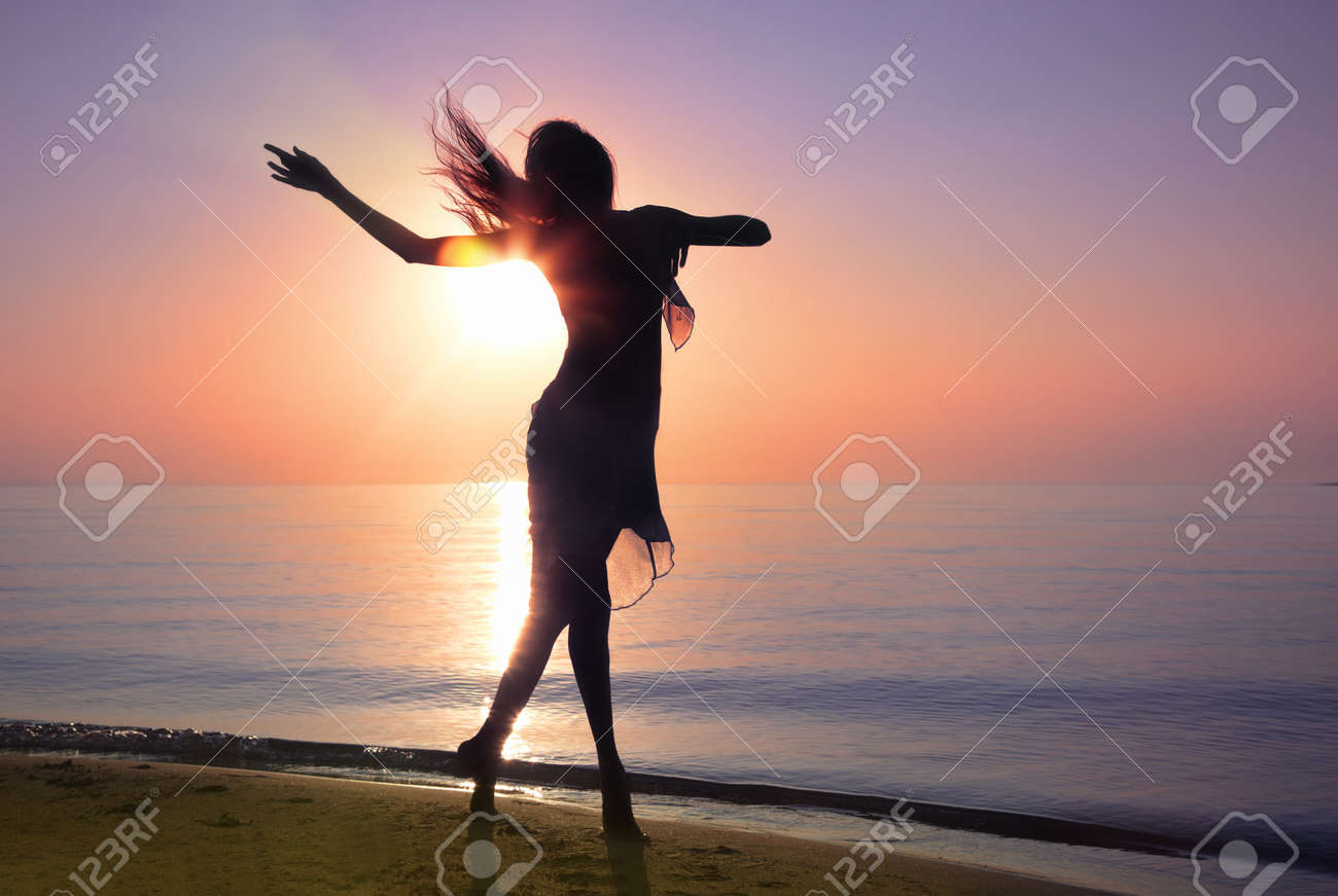 Silhouette of the woman dancing at the beach during beautiful sunrise. Natural light and darkness. Artistic vivid colors added - 8908441 Silhouette of the woman dancing at the beach during beautiful sunrise. Natural light and darkness. Artistic vivid colors added - 8908441