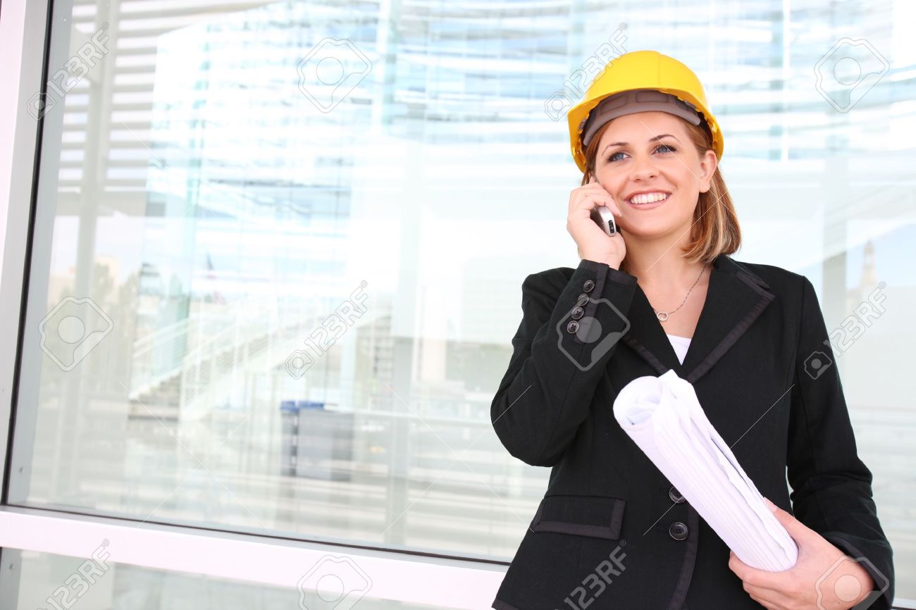 a woman construction manager on a building site talking on phone bilding manager