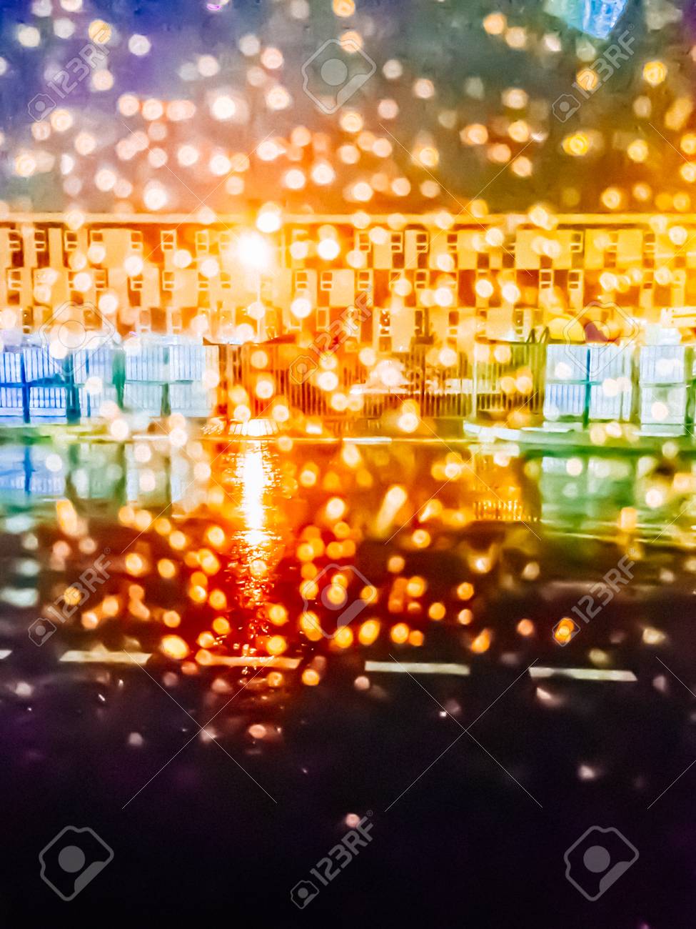 ガラス上の雨の中を夜の街の明かりの不鮮明な画像を削除します の写真素材 画像素材 Image