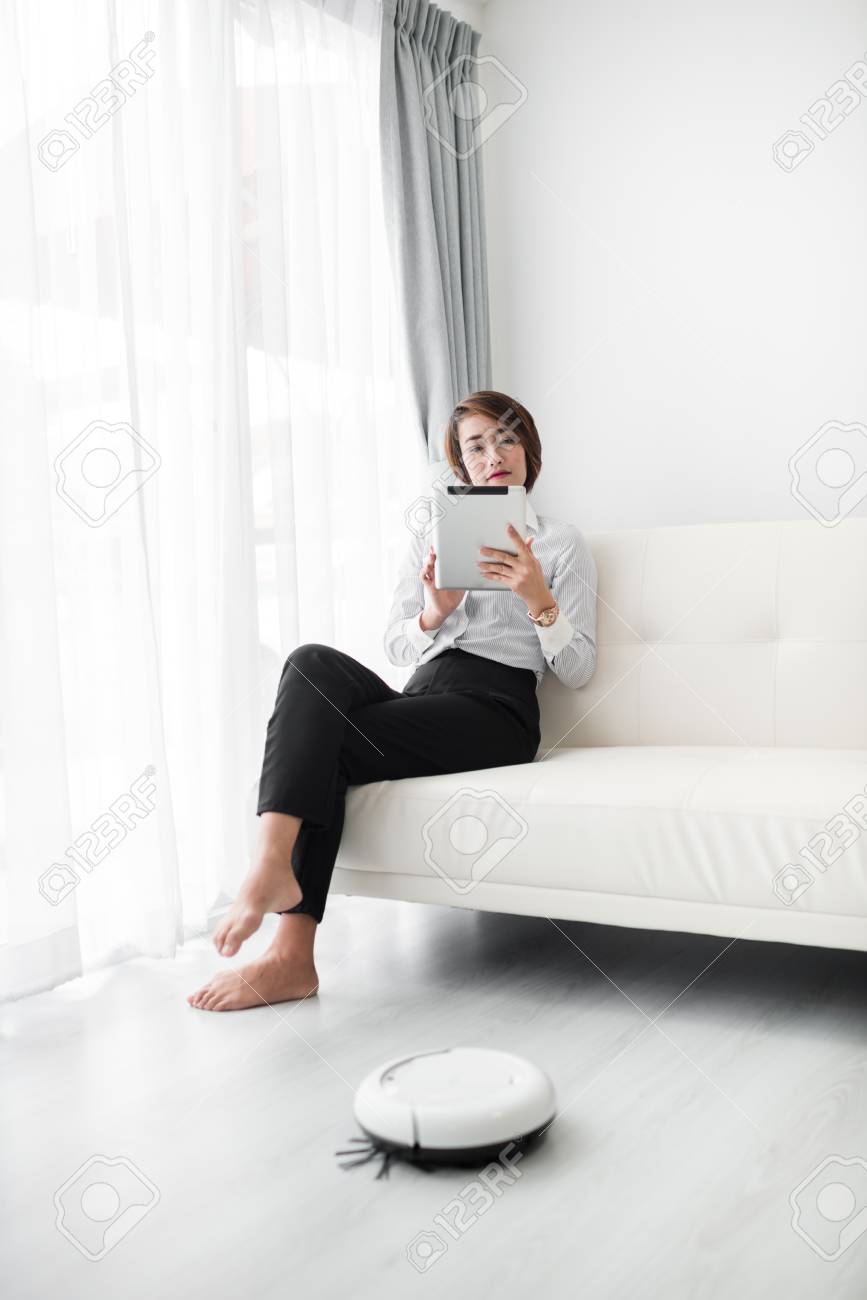Smart businesswoman using smart phone and cleaning robot, lifestyle concept. - 95637388 Smart businesswoman using smart phone and cleaning robot, lifestyle concept. - 95637388