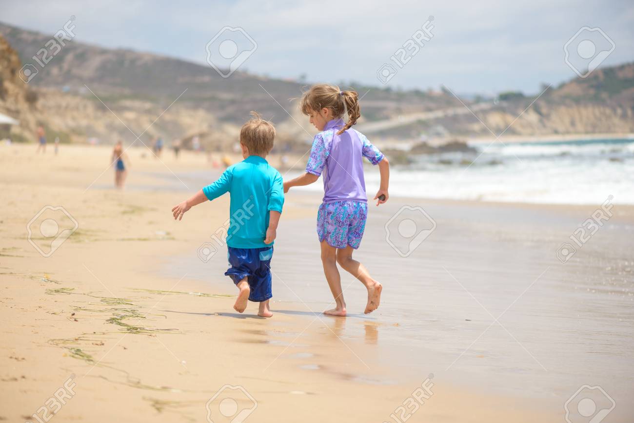Happy kids running on the beach near the ocean - 106235230 Happy kids running on the beach near the ocean - 106235230