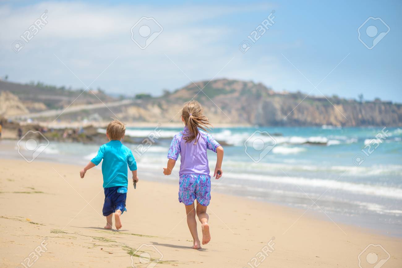 Happy kids running on the beach near the ocean - 106235234 Happy kids running on the beach near the ocean - 106235234