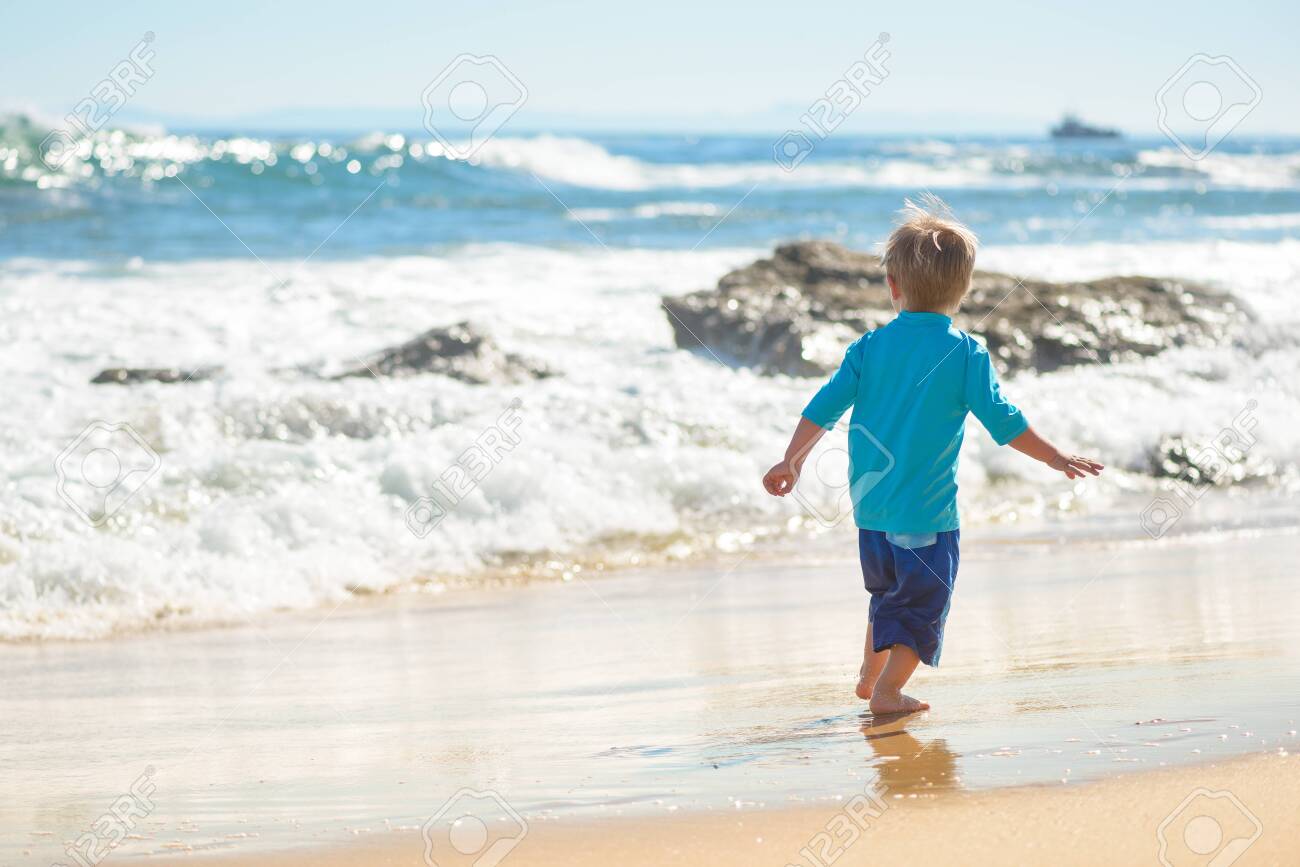 Happy boy running on the beach in the waves - 115343690 Happy boy running on the beach in the waves - 115343690