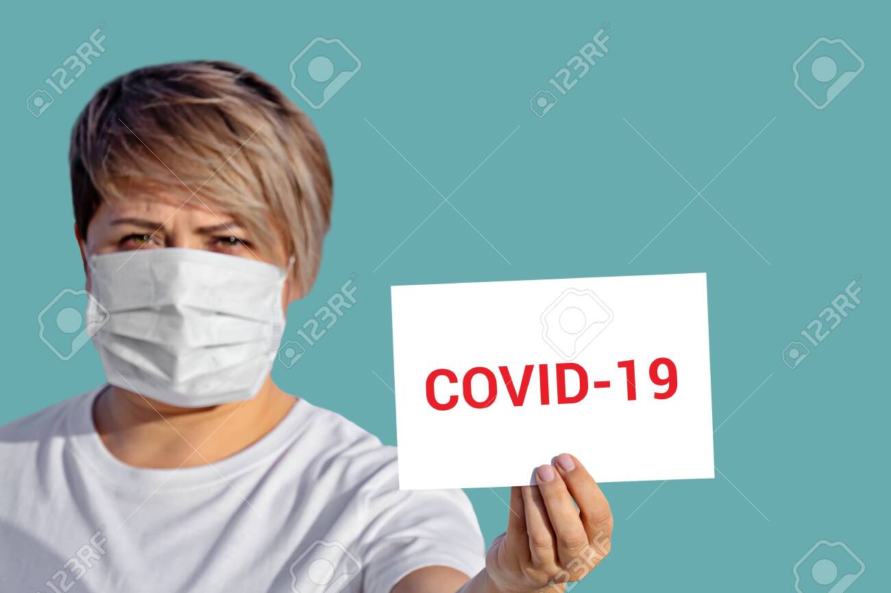 Woman in face mask hold blank with inscription COVID-19. World Health Organization WHO introduced new official name for coronavirus COVID-19 - 140016707 Woman in face mask hold blank with inscription COVID-19. World Health Organization WHO introduced new official name for coronavirus COVID-19 - 140016707