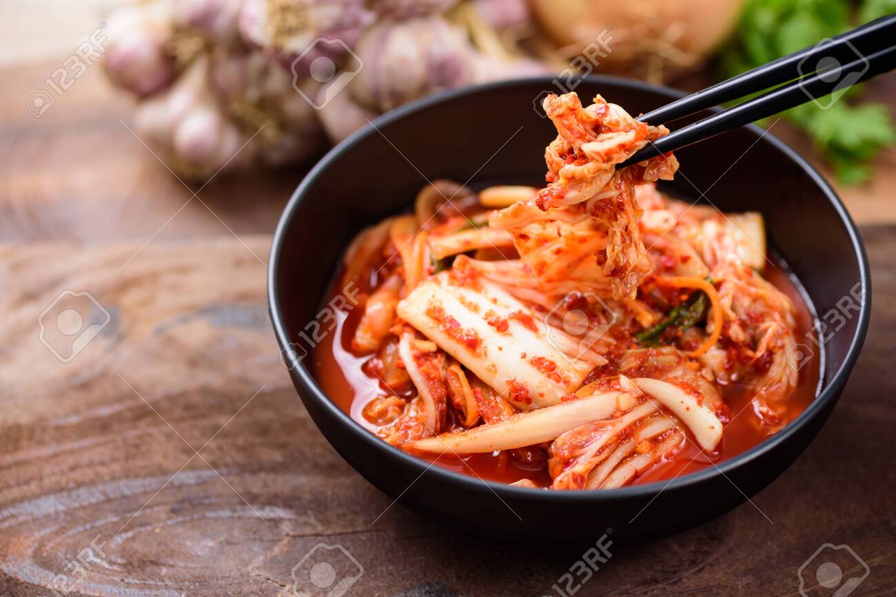 Eating kimchi cabbage in a bowl with chopsticks, Korean food - 128799333 Eating kimchi cabbage in a bowl with chopsticks, Korean food - 128799333
