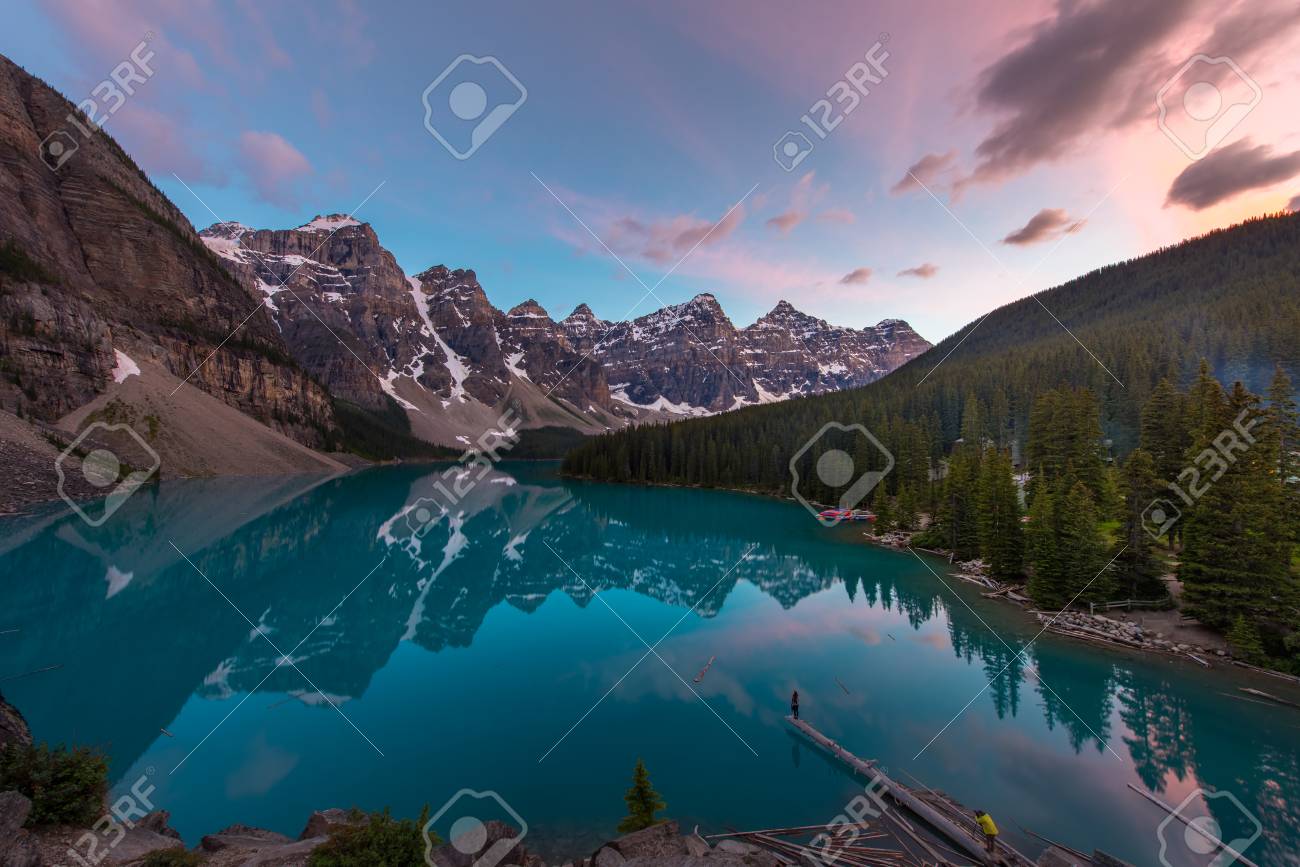 The Moraine Lake with turquoise lake and mountain reflection in sunset beautiful sky and photographer taking model by the lake - 115023907 The Moraine Lake with turquoise lake and mountain reflection in sunset beautiful sky and photographer taking model by the lake - 115023907