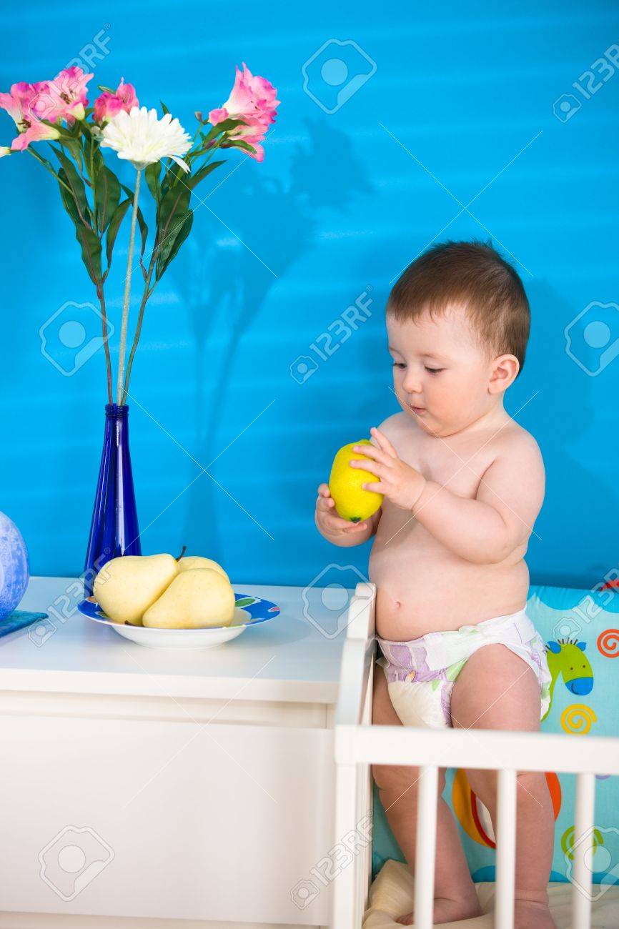 Sweet Baby Boy 1 An Dans La Couche Debout Sur Un Lit De Bebe Et Manger Des Fruits Sains Banque D Images Et Photos Libres De Droits Image