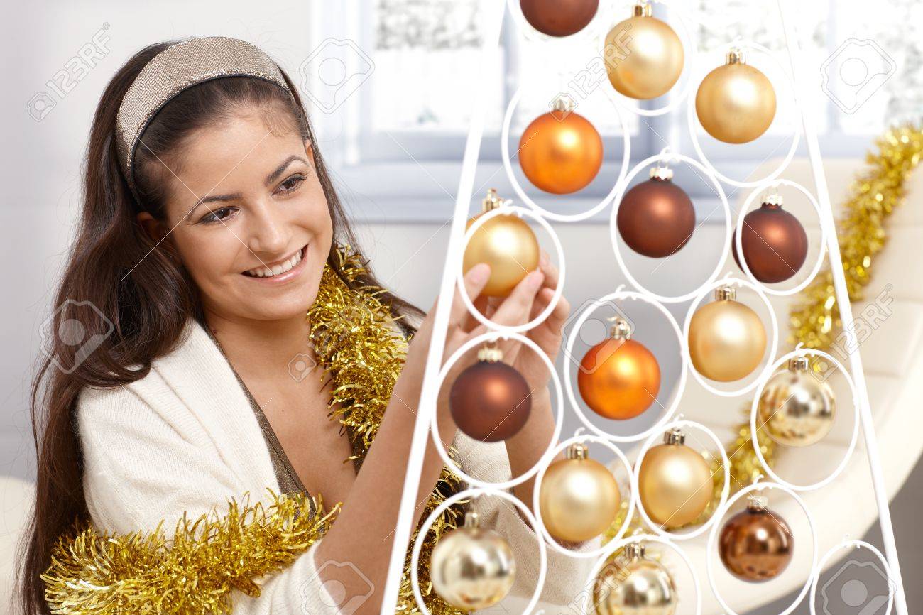 Woman Home Decorating smiling young woman getting ready for christmas, decorating with Woman Home Decorating smiling young woman getting ready for christmas, decorating with