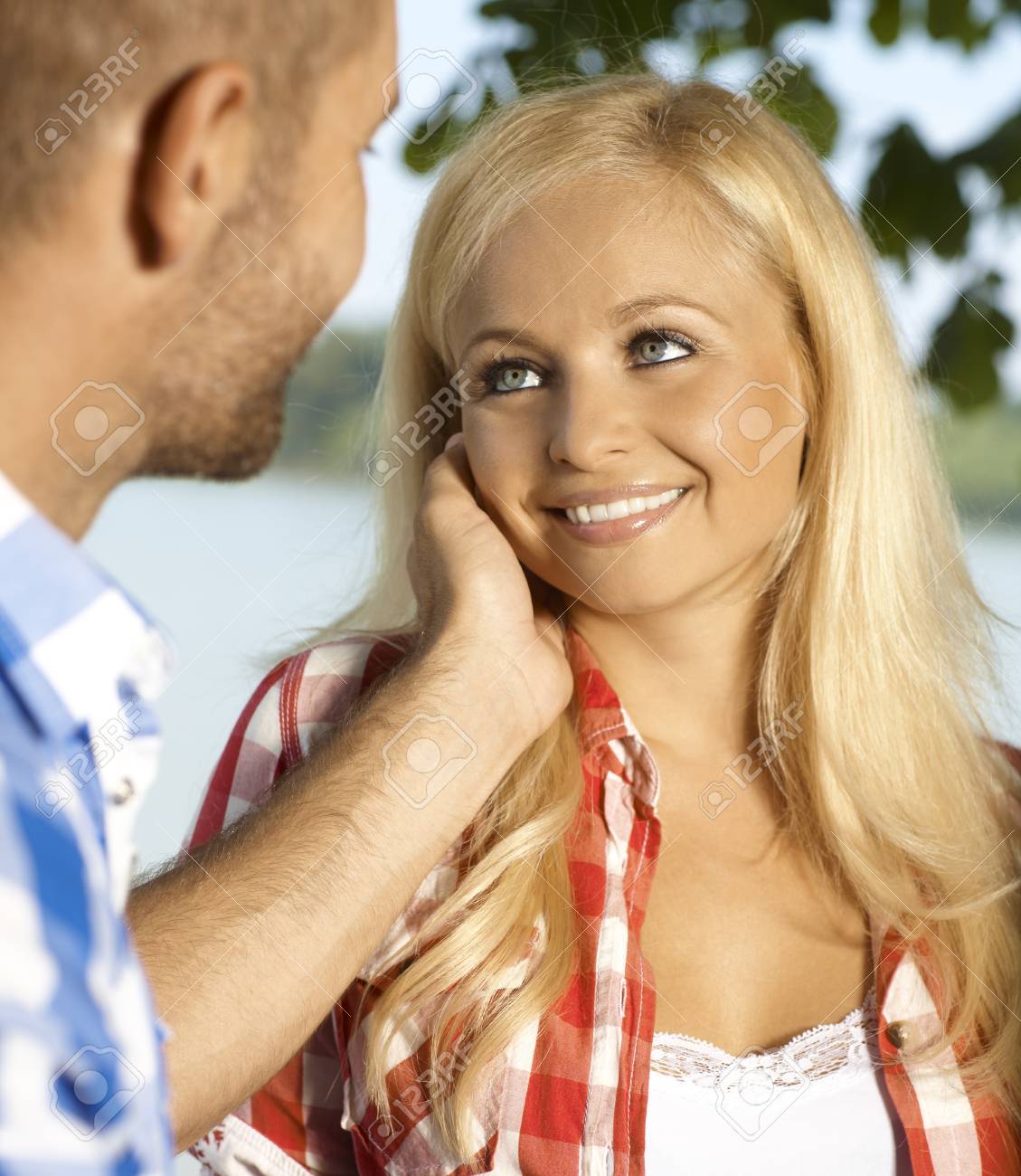 幸せな魅力的なカジュアルな金髪白人のロマンチックな女性の笑顔は 屋外愛撫 の写真素材 画像素材 Image